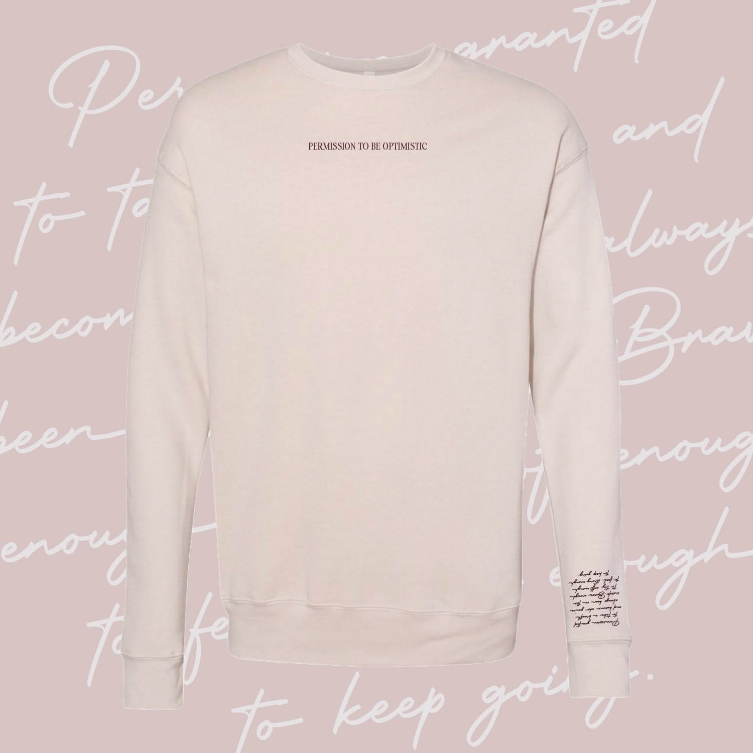 Dust crewneck with "Permission To Be Optimistic" on chest and permission to be paragraph printed on sleeve, shown on flat lay - Little Mama Shirt Shop
