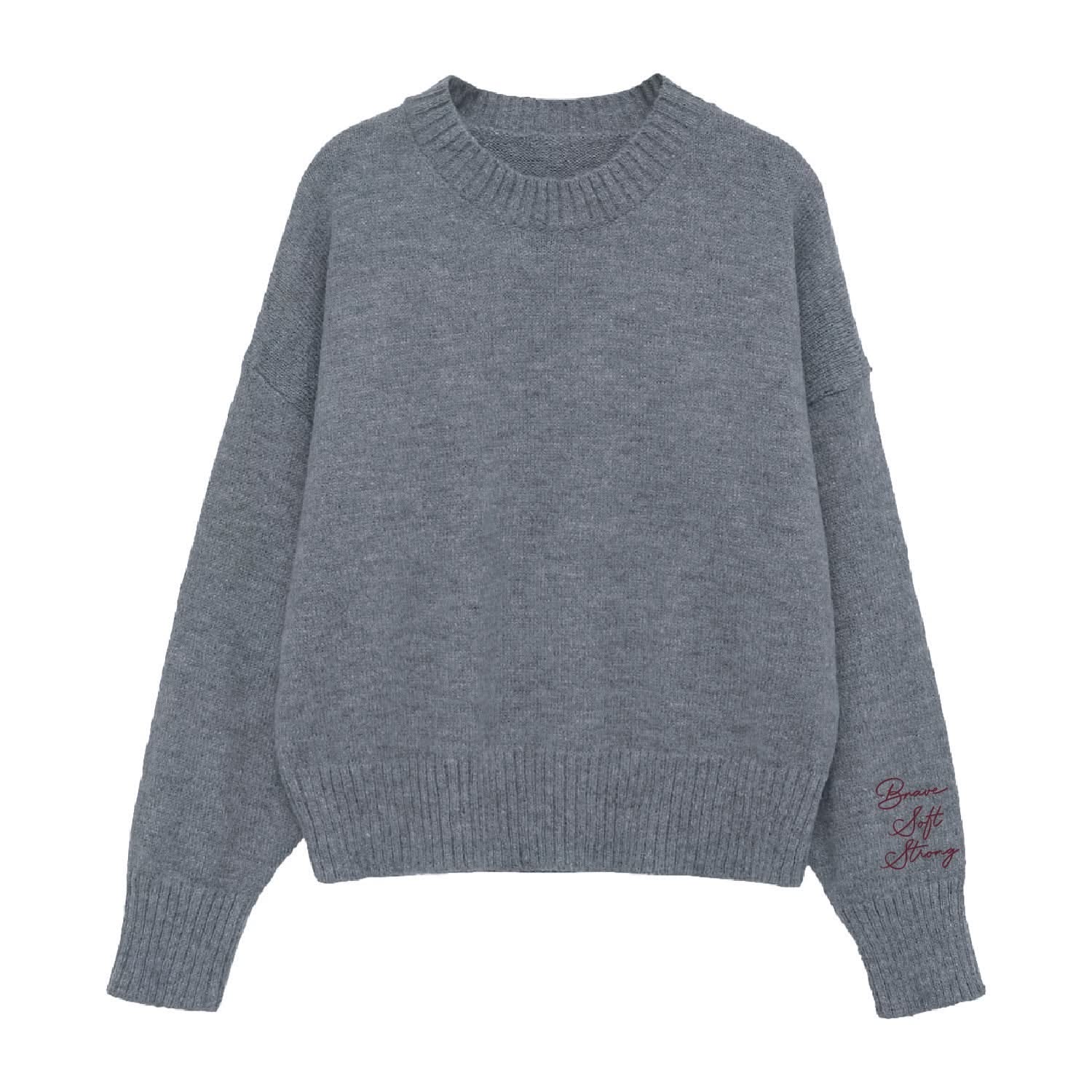 Gray sweater with "Brave, Soft, Strong" embroidered on the sleeve, seen on flat lay - Little Mama Shirt Shop