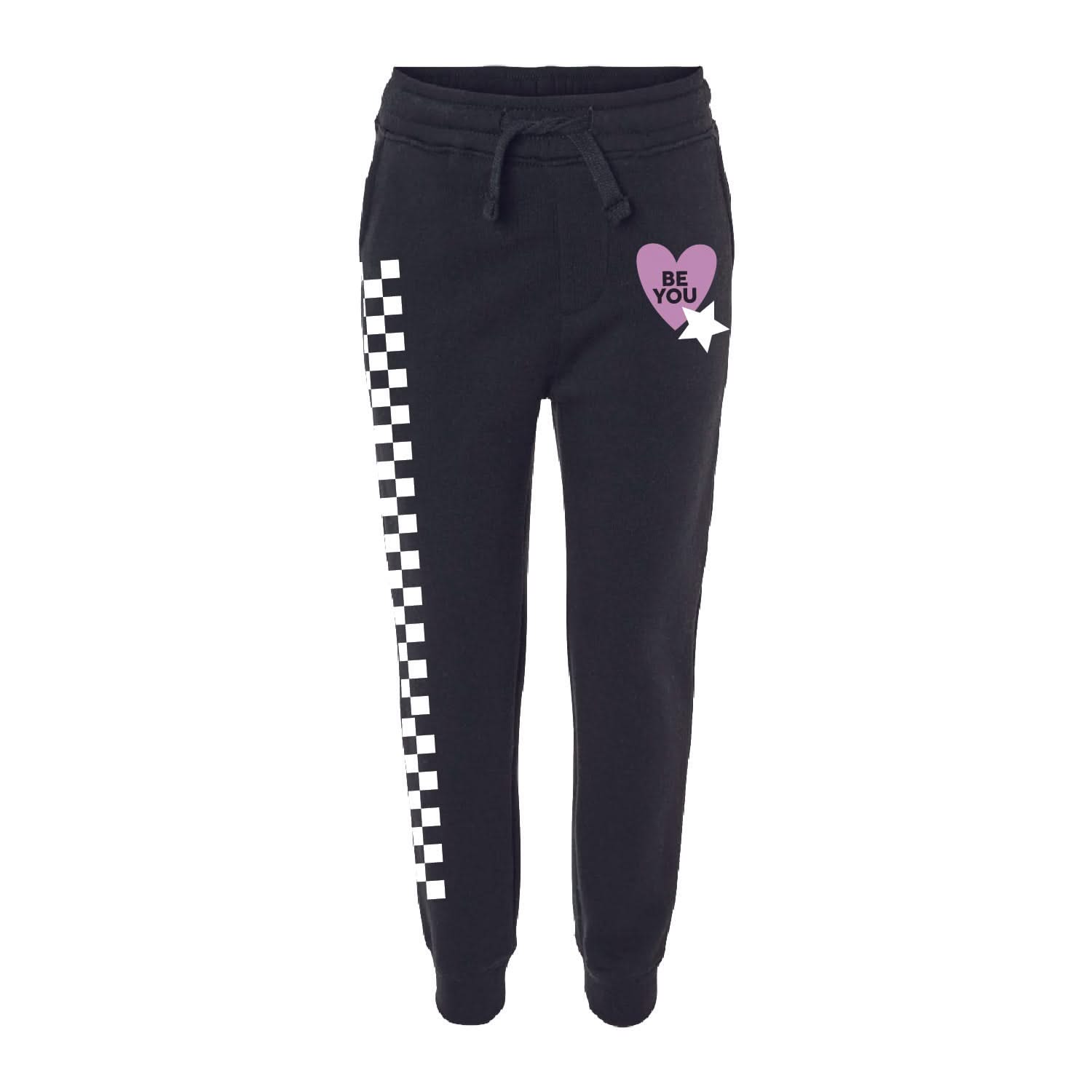 Child black joggers with checkers pattern on leg, and Purple Heart with 'be you' in it flanked by a white star, seen on flat lay - Little Mama Shirt Shop