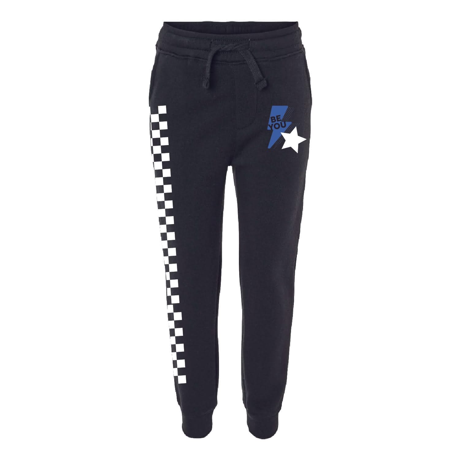 Child black joggers with checkers pattern on leg, and blue lightning bolt with 'be you' in it flanked by a white star, seen on flat lay - Little Mama Shirt Shop