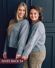 Gray sweater with "Brave, Soft, Strong" embroidered on the sleeve, seen on models - Little Mama Shirt Shop
