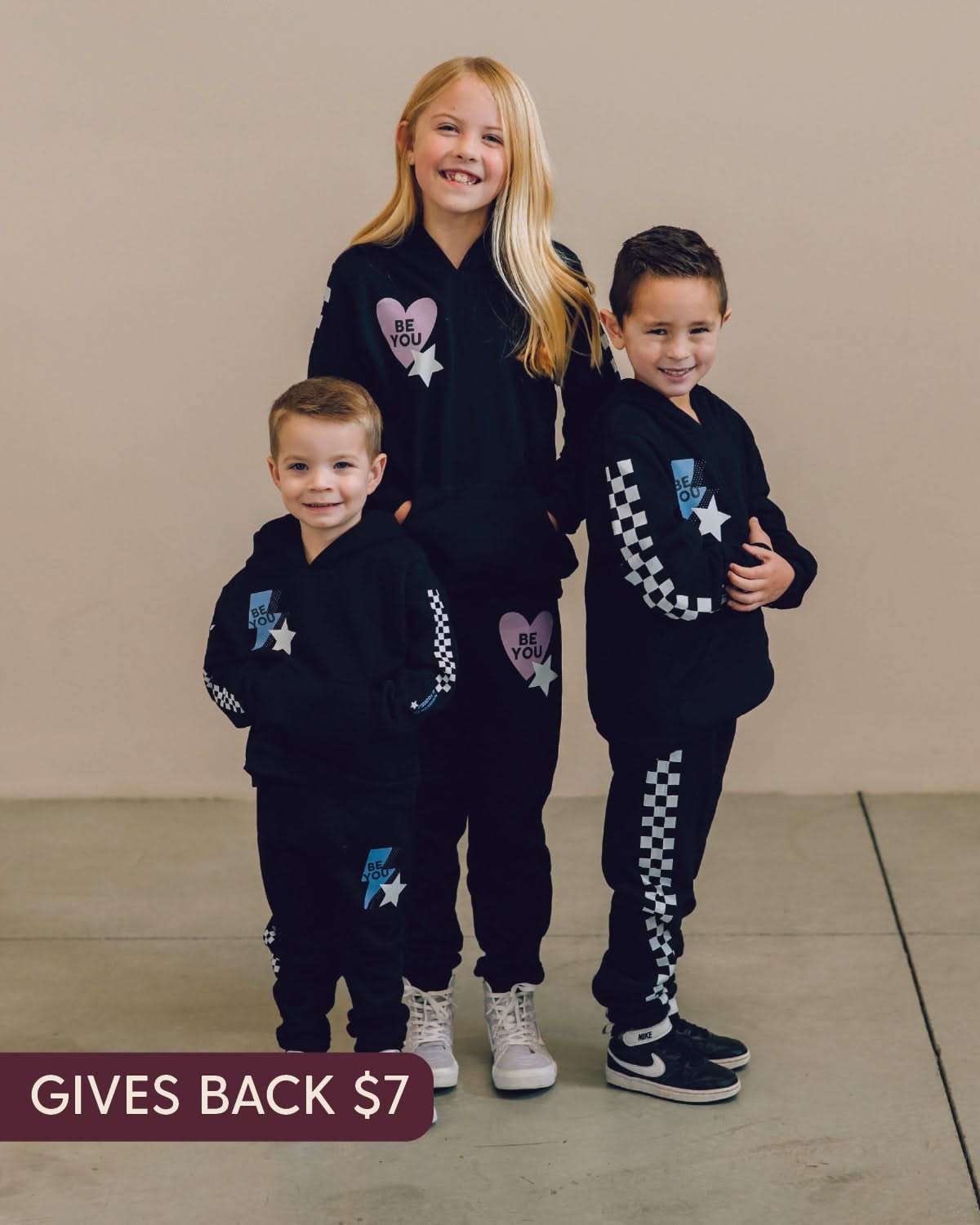 Child black sweater and joggers with checkers pattern on arm and leg, and Purple Heart or blue lightning bolt with 'be you' in it flanked by a white star, seen on models - Little Mama Shirt Shop