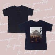 Black child tee with permission to be mountain graphic on back and 'daily reminder' printed on front, seen on flat lay - Little Mama Shirt Shop