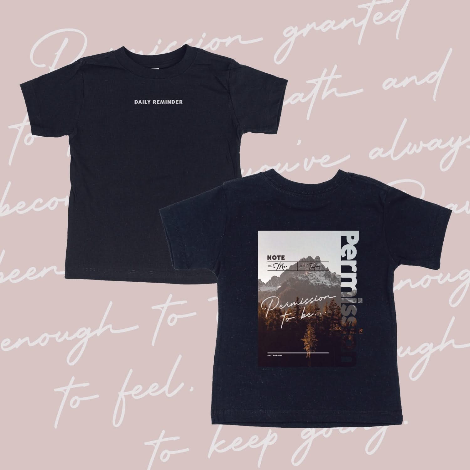 Black child tee with permission to be mountain graphic on back and 'daily reminder' printed on front, seen on flat lay - Little Mama Shirt Shop