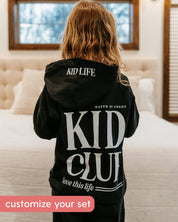 Hoodie back view in black with white 'Kid Club' graphic on model - Little Mama Shirt Shop
