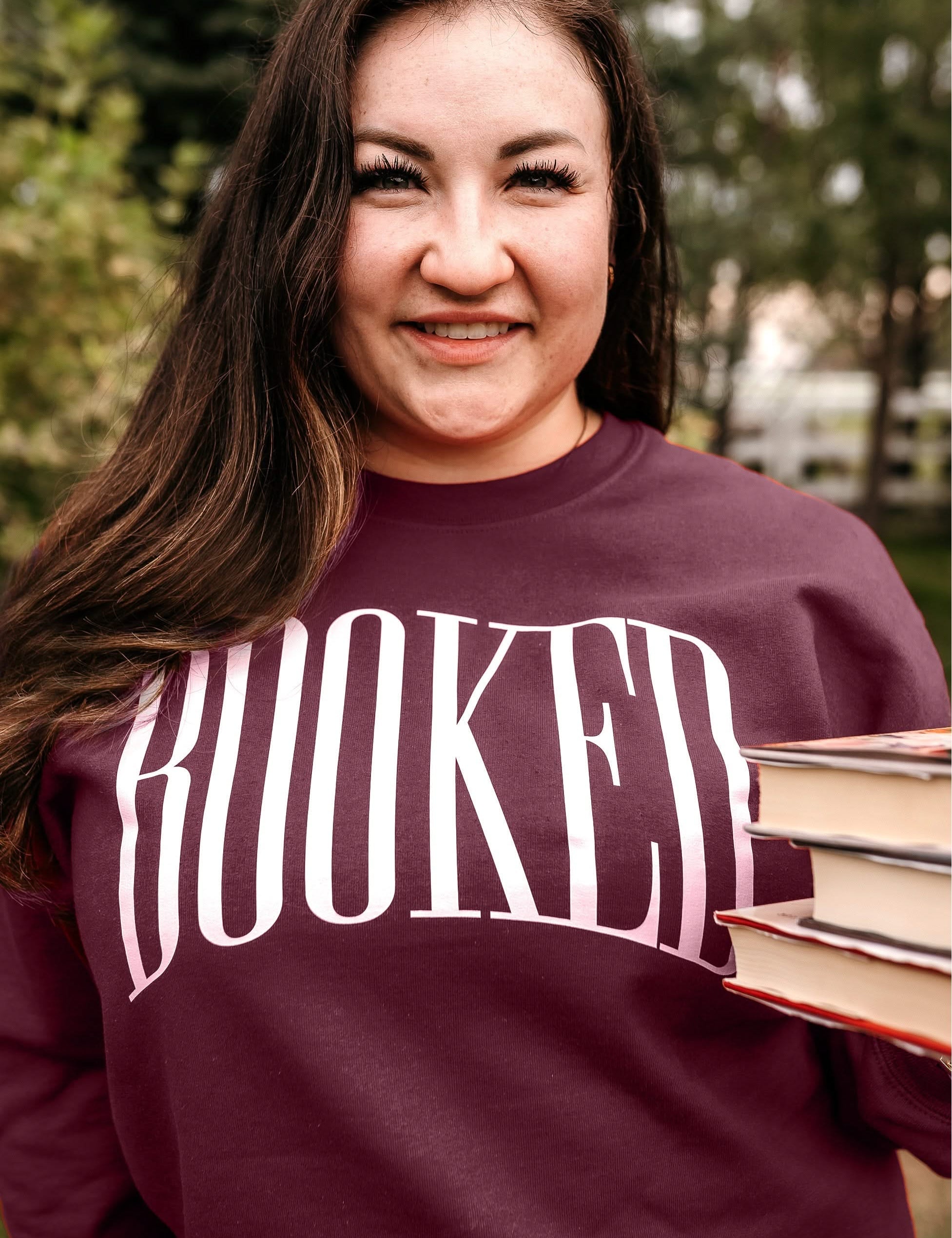 Basic fleece in maroon with 'BOOKED' graphic on chest, shown on model – Little Mama Shirt Shop
