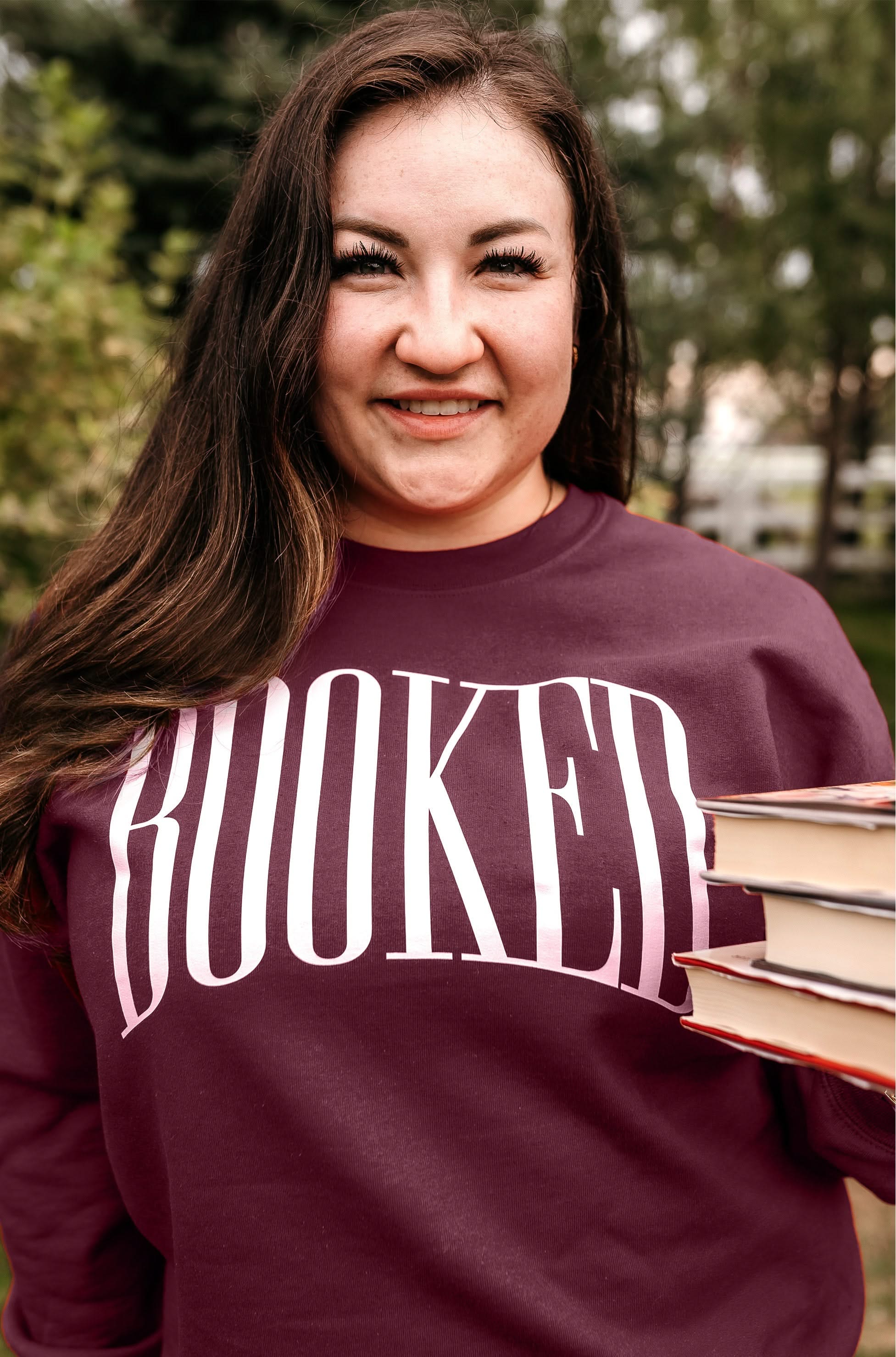 Basic fleece in maroon with 'BOOKED' graphic on chest, shown on model – Little Mama Shirt Shop