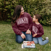 Mommy and me sweaters in maroon with 'BOOKED' graphic on chest, shown on models – Little Mama Shirt Shop