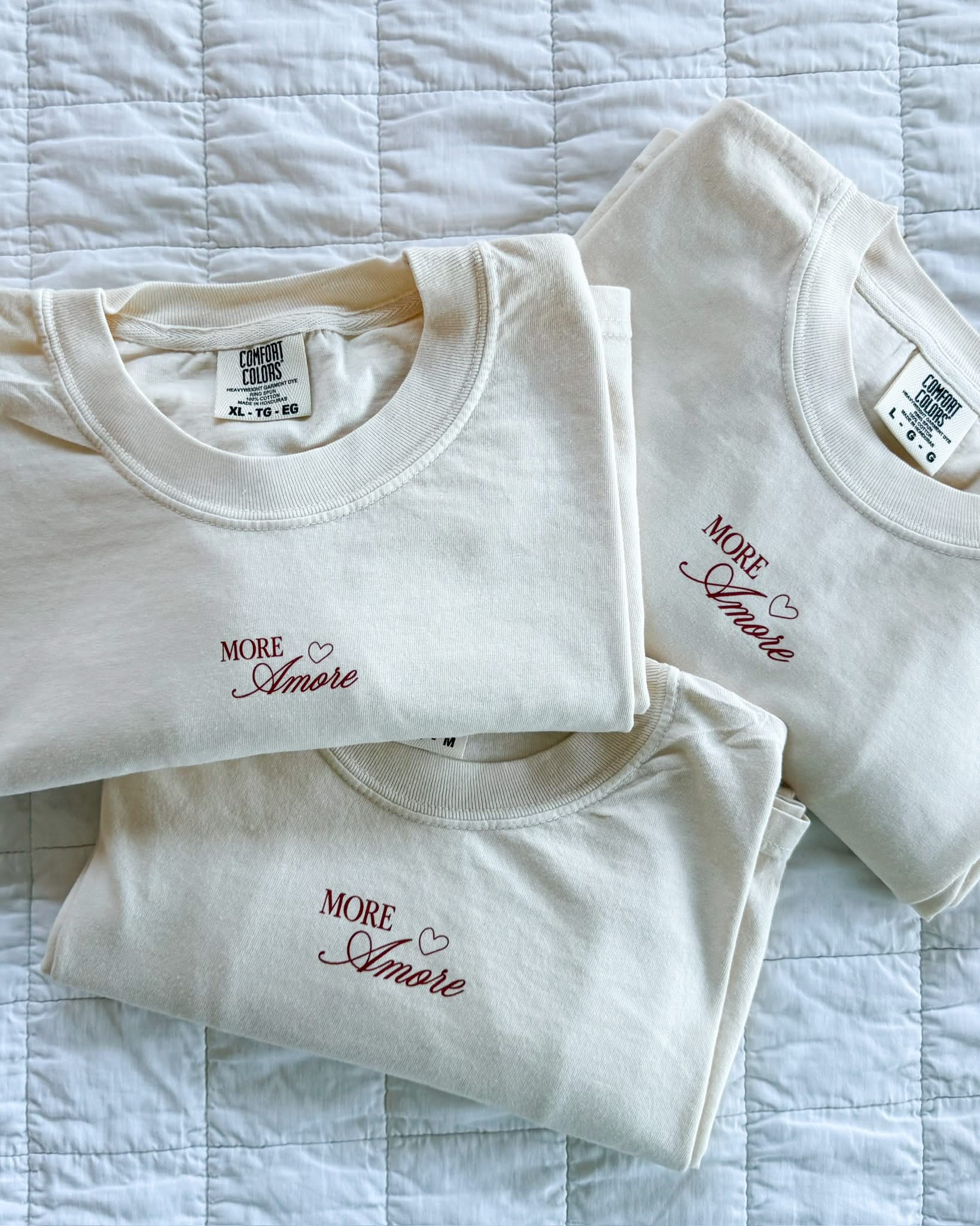 Adult tee in ivory with "More Amore" print on front, shown on flat lay – Little Mama Shirt Shop