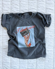 Child tee with "I Don't Care" retro cassette on front and "JK I Actually Do" text on sleeve, shown on flat lay  – Little Mama Shirt Shop