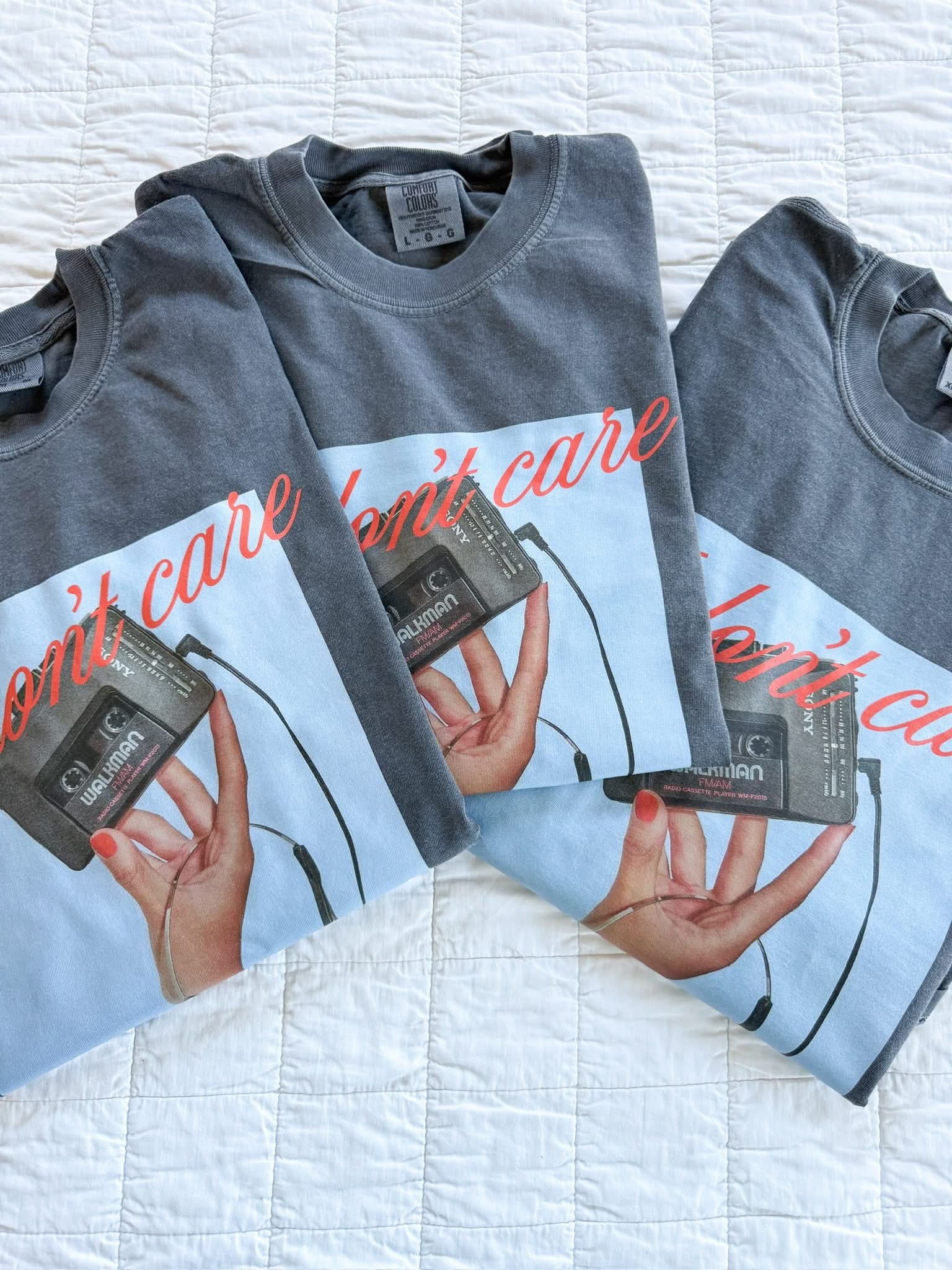 Adult tee with "I Don't Care" retro cassette design on front, shown on flat lay  – Little Mama Shirt Shop