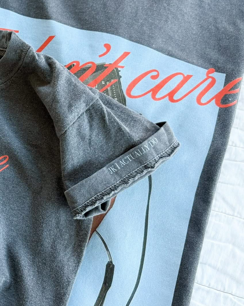 Adult tee with "I Don't Care" retro cassette on front and "JK I Actually Do" text on sleeve, shown on flat lay  – Little Mama Shirt Shop