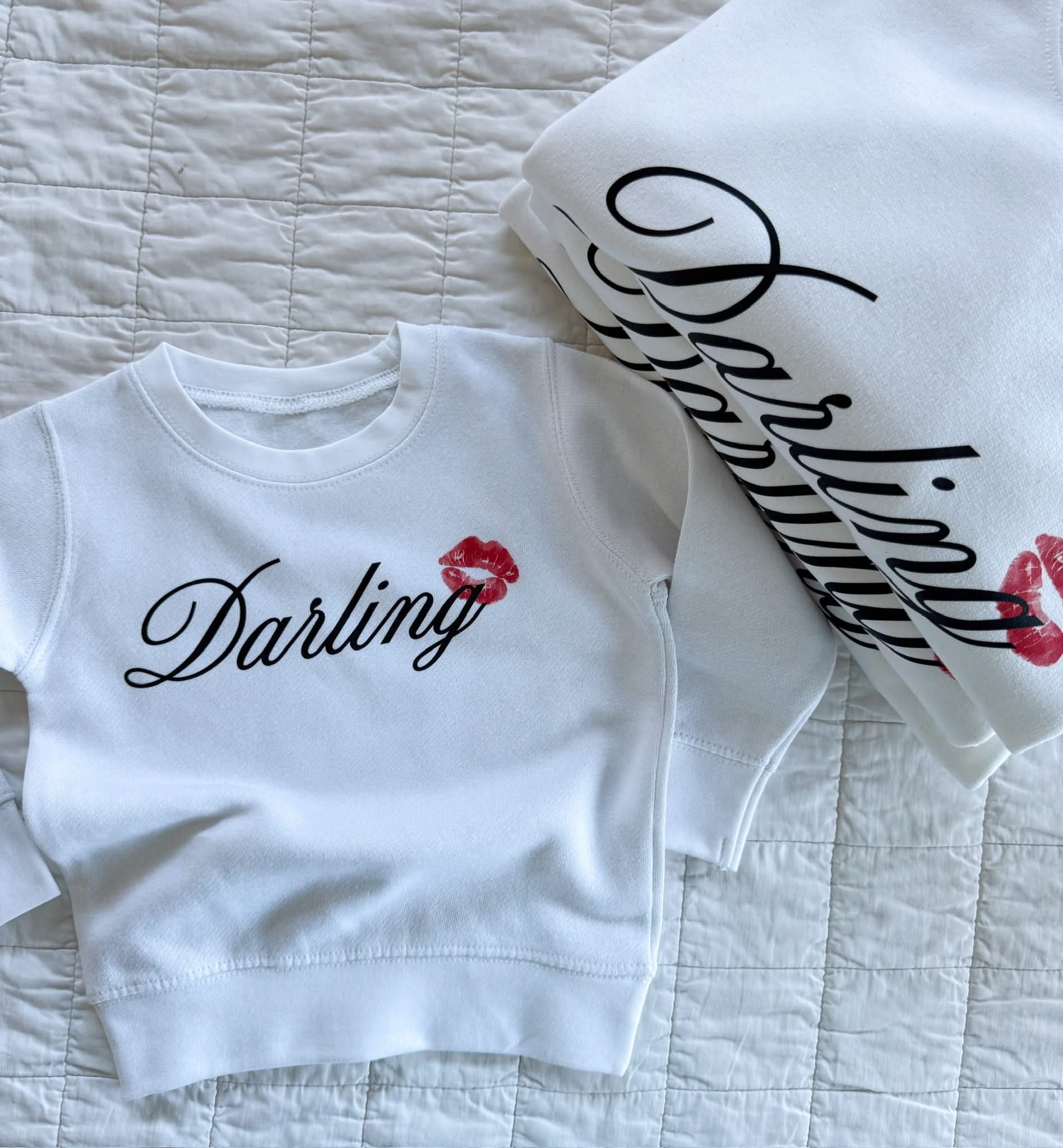 youth white sweater with "Darling" script and lipstick kiss design, shown on flat lay  – Little Mama Shirt Shop