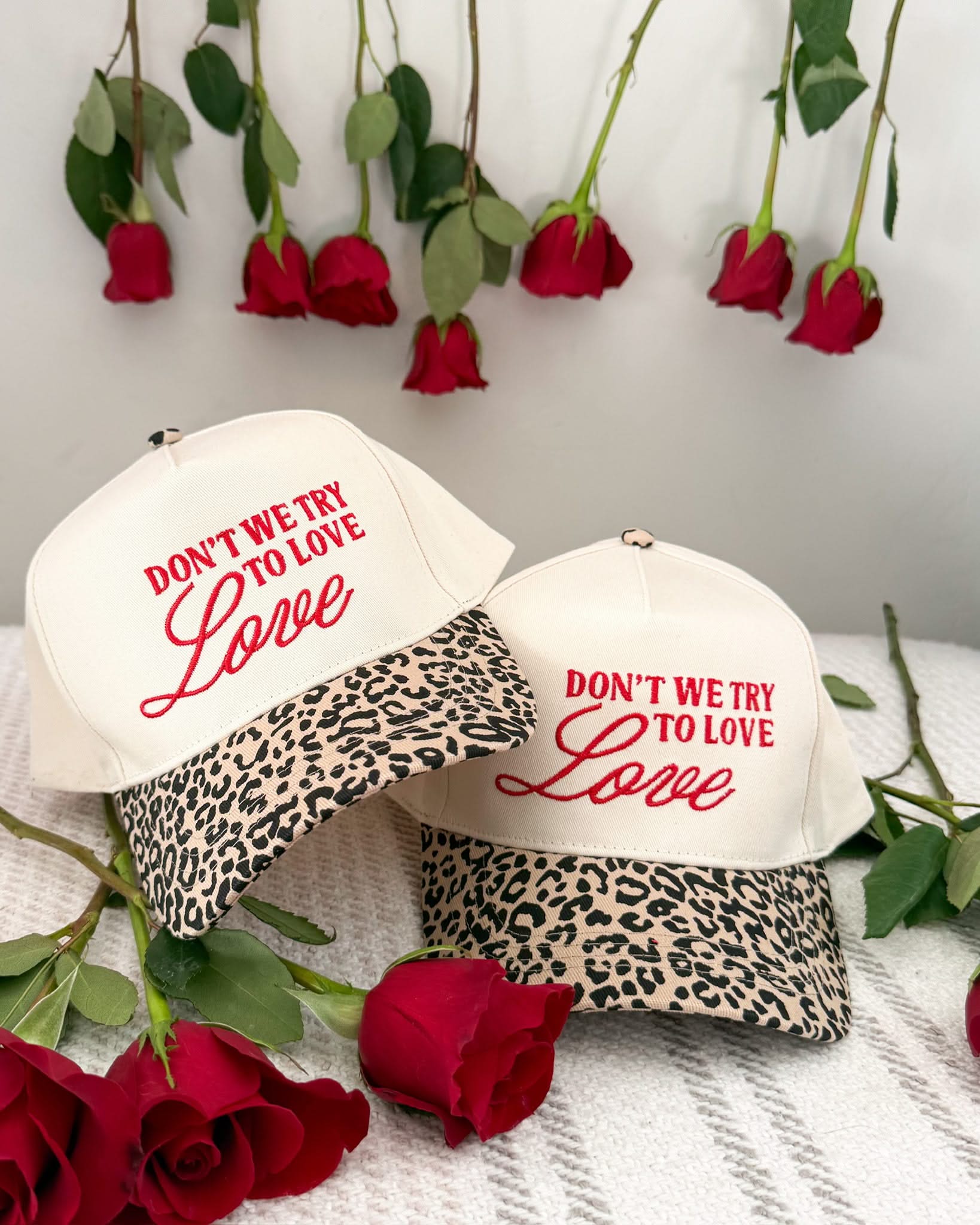 Adult cream and leopard hat with "Don't We Try To Love Love" design embroidered on front, shown on flat lay – Little Mama Shirt Shop