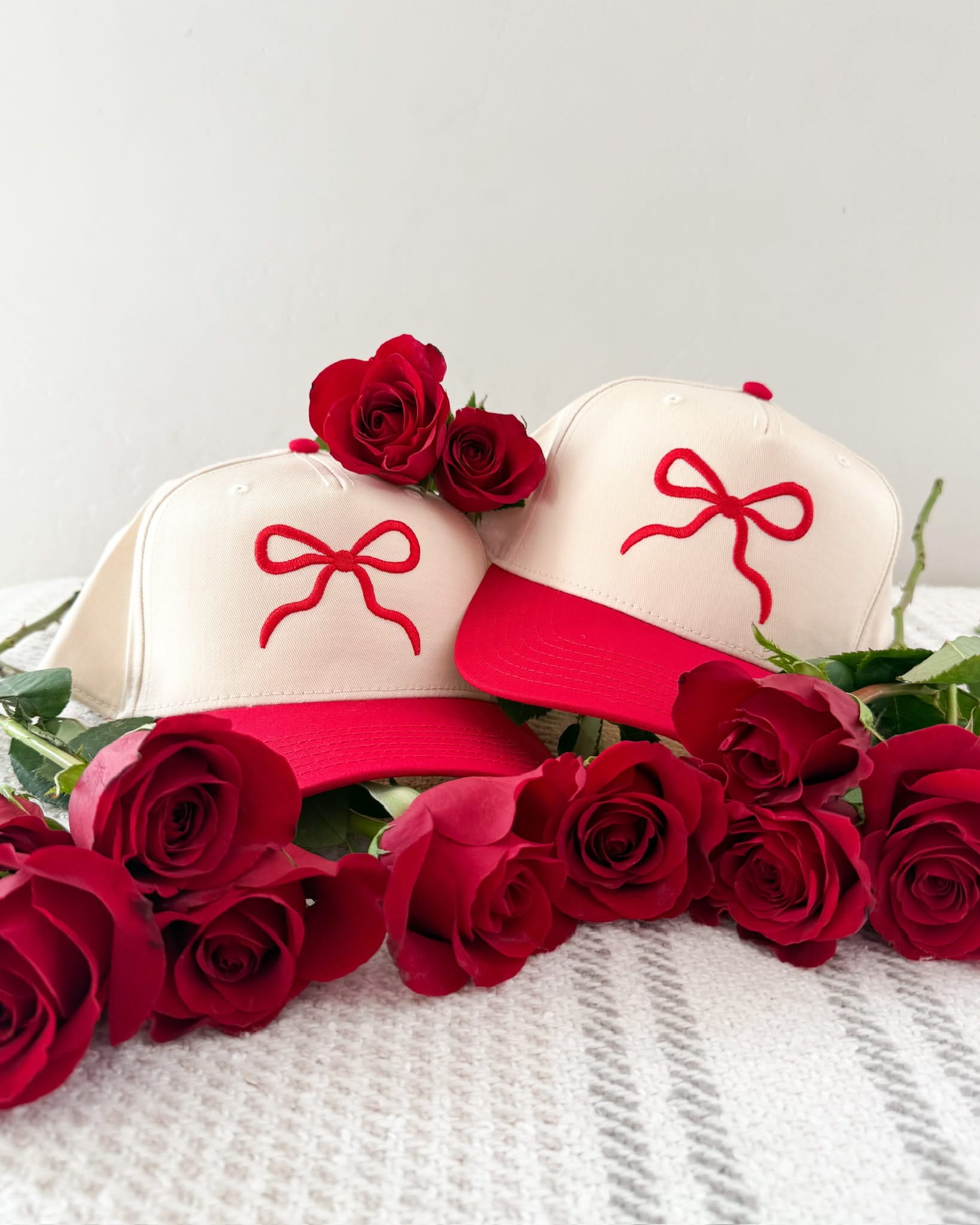 Adult cream and red hat with Red Puff Bow Embroidery on front, shown on flat lay – Little Mama Shirt Shop