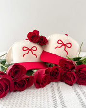 Adult cream and red hat with Red Puff Bow Embroidery on front, shown on flat lay – Little Mama Shirt Shop