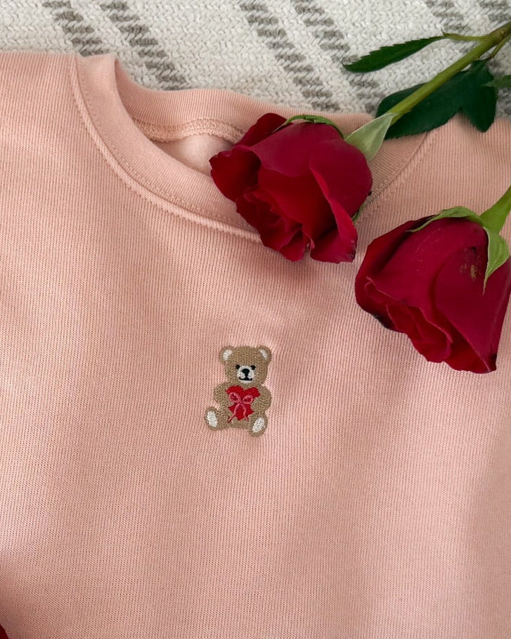 Adult pink sweater with valentine's teddy Embroidery on front, shown on flat lay  – Little Mama Shirt Shop