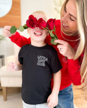 Child tee in black with "Little Love Club" bubble letter text design on front left chest, shown on model – Little Mama Shirt Shop