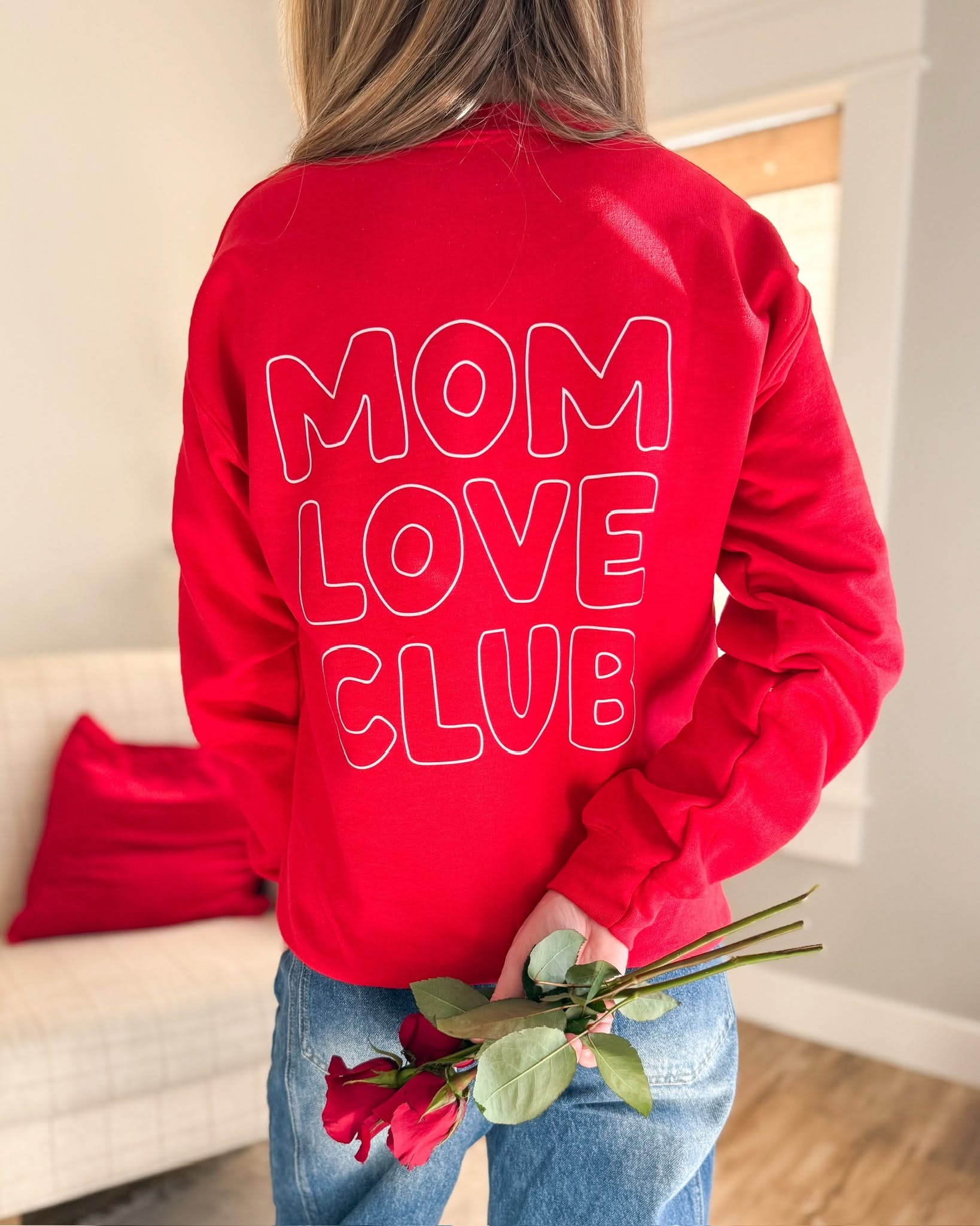 Adult sweater in red with "Mom Love Club" bubble letter text design on back, shown on model – Little Mama Shirt Shop