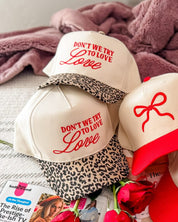 Adult cream and leopard hat with "Don't We Try To Love Love" design embroidered on front, shown on flat lay – Little Mama Shirt Shop
