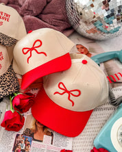 Adult cream and red hat with Red Puff Bow Embroidery on front, shown on flat lay – Little Mama Shirt Shop