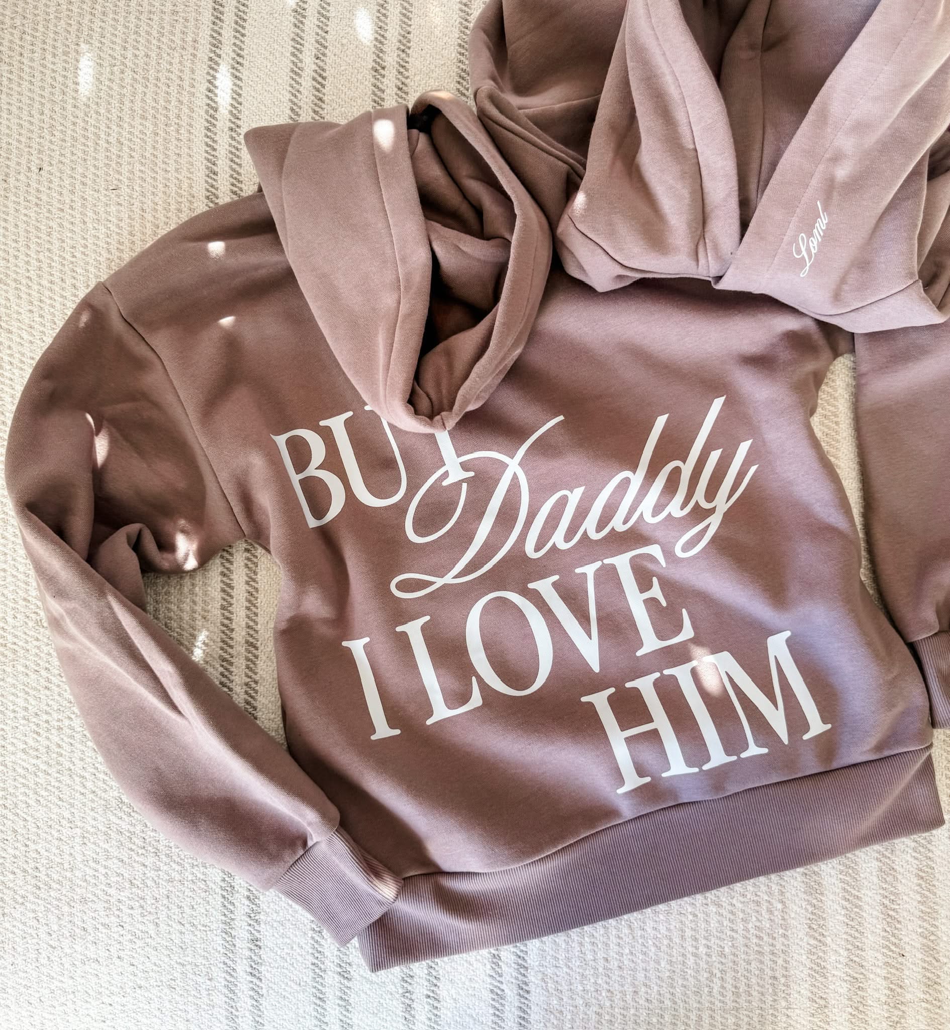 Adult hoodie in brown with "But Daddy I Love Him" design on back and "loml" script on hood, shown on flat lay – Little Mama Shirt Shop