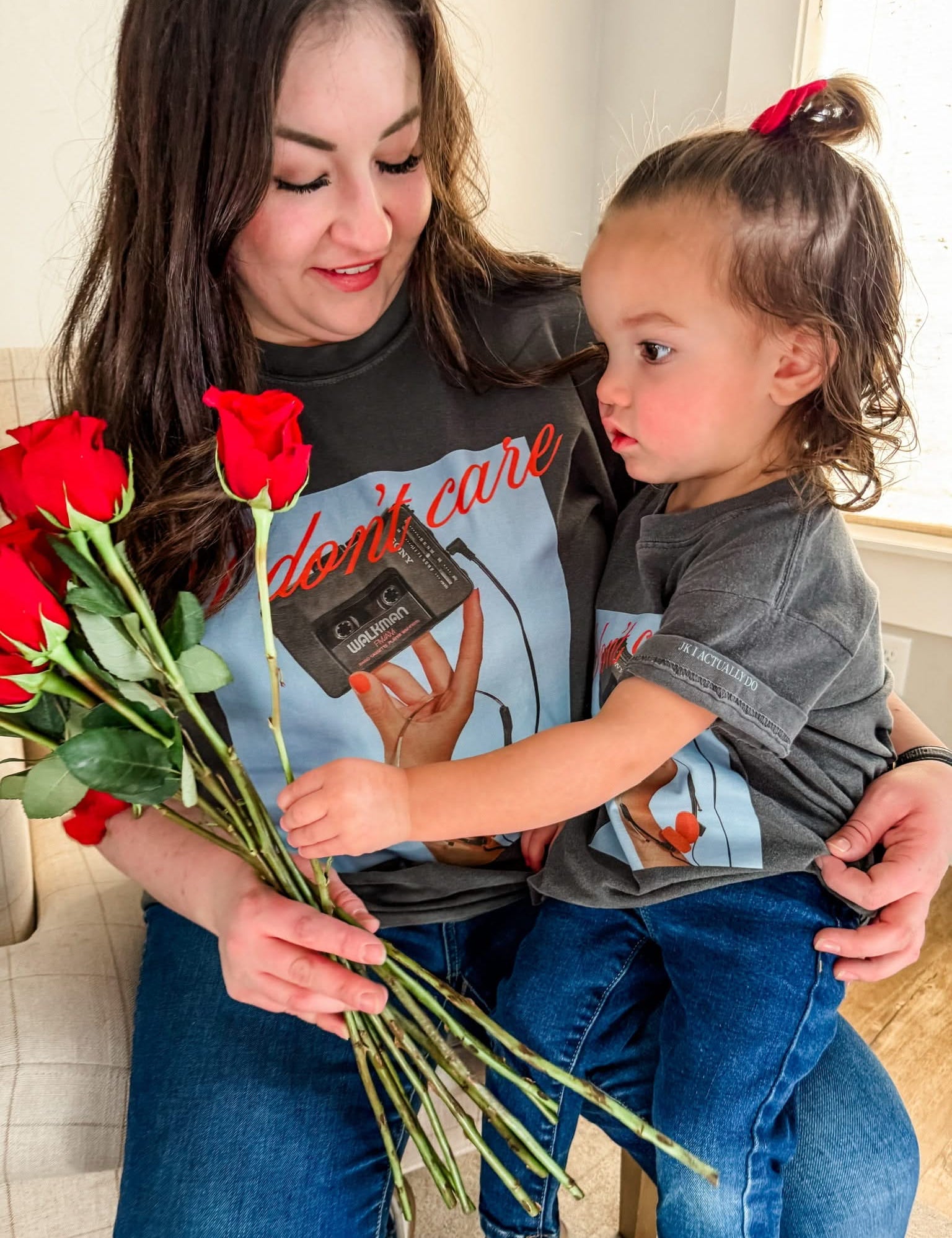 Adult and child tee with "I Don't Care" retro cassette on front and "JK I Actually Do" text on sleeve, shown on models  – Little Mama Shirt Shop