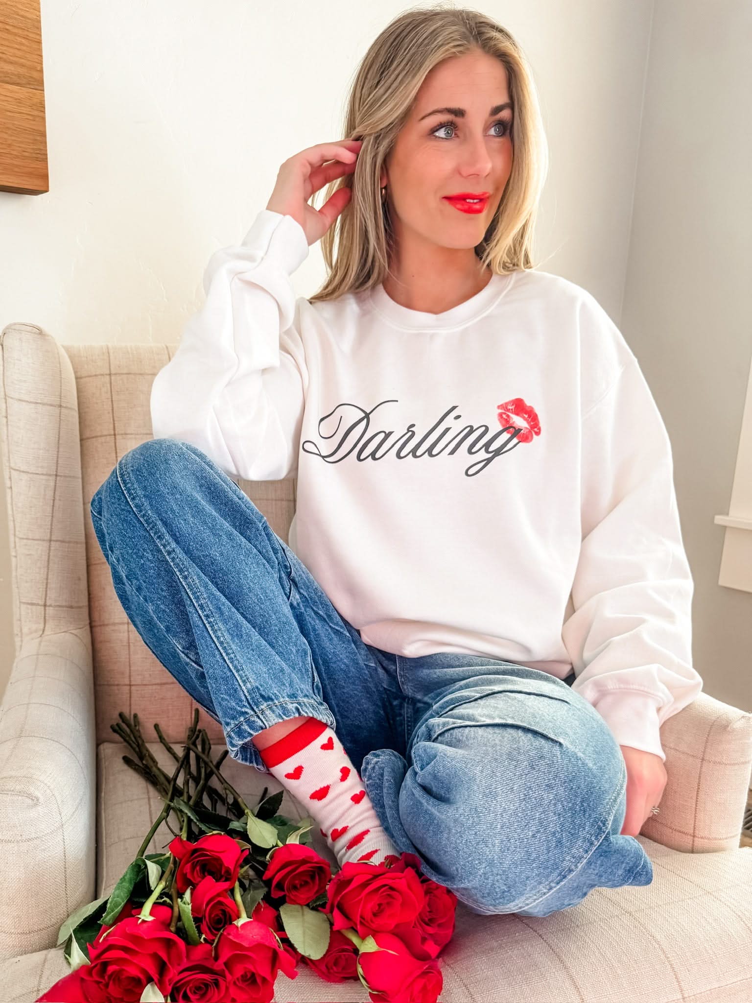 Adult white sweater with "Darling" script and lipstick kiss design, shown on model  – Little Mama Shirt Shop