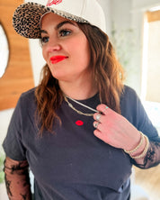 Adult tee in dark gray with mini symbol lips design on front, shown on model – Little Mama Shirt Shop