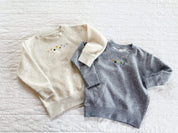 Natural heather and gray child sweater with printed lucky charm marshmallows design on chest, seen on flat lay - Little Mama Shirt Shop