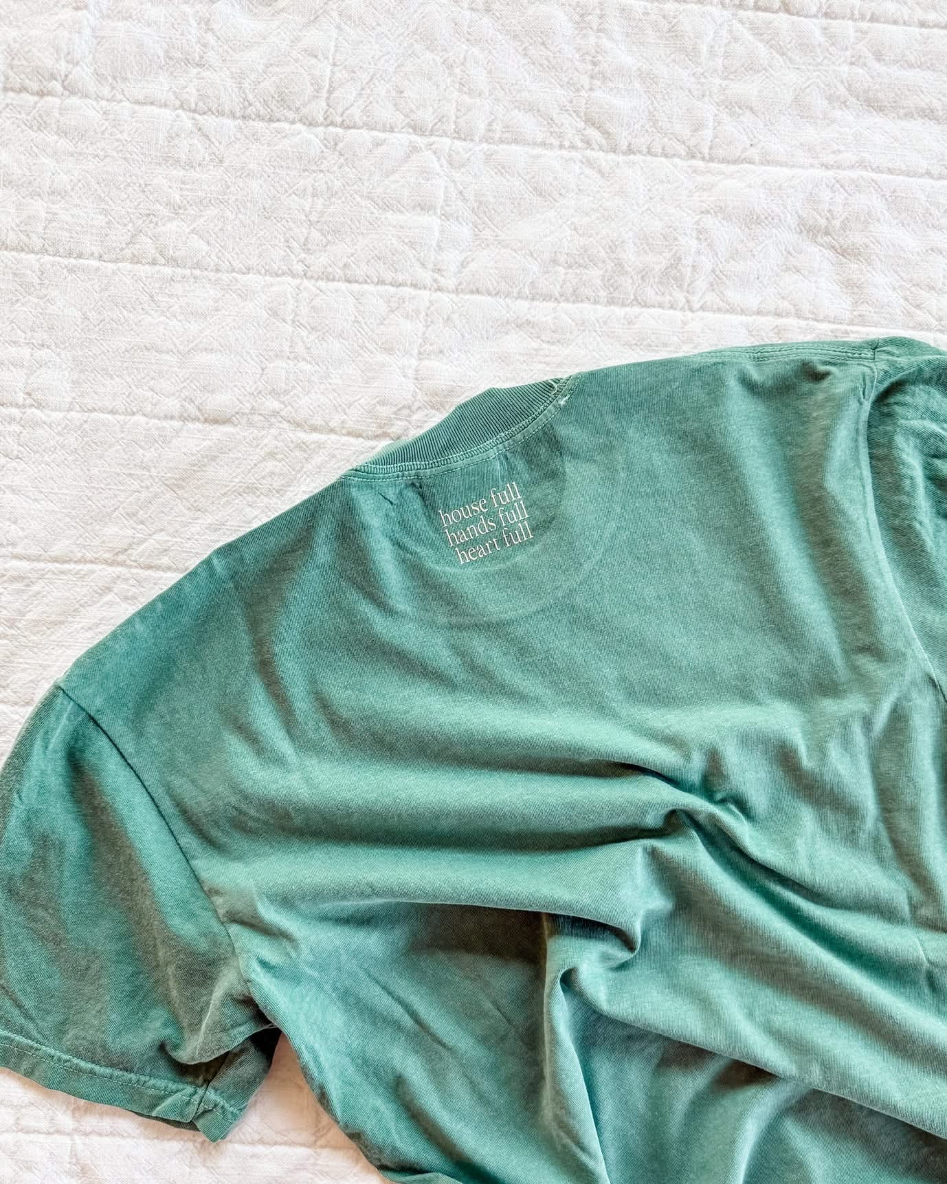 Adult tee in alpine with 'house full, hands full, heart full' printed on the back collar, seen on flat lay - Little Mama Shirt Shop