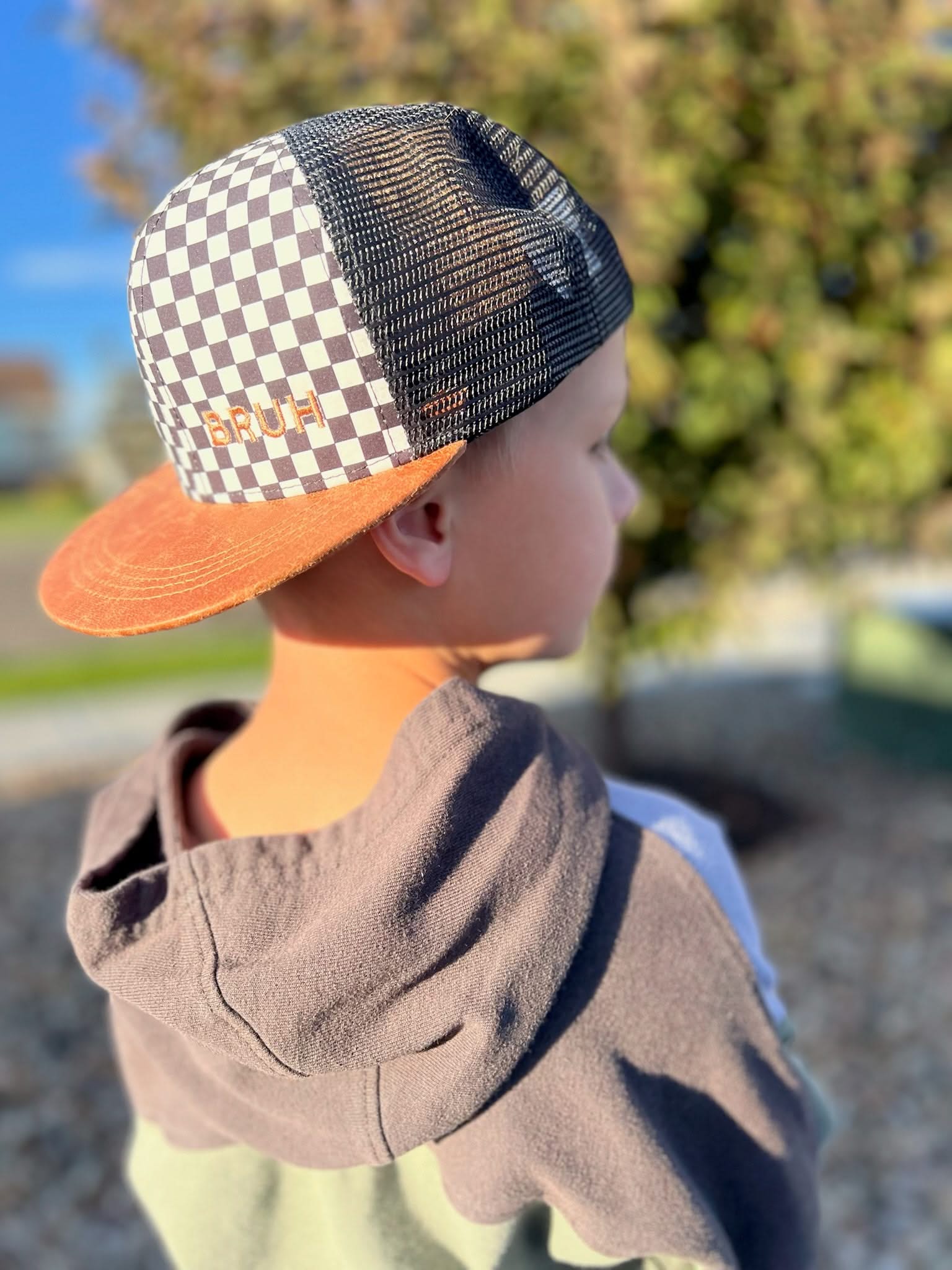 Child hat in brown and checkered with "Bruh" embroidered design, seen on model - Little Mama Shirt Shop