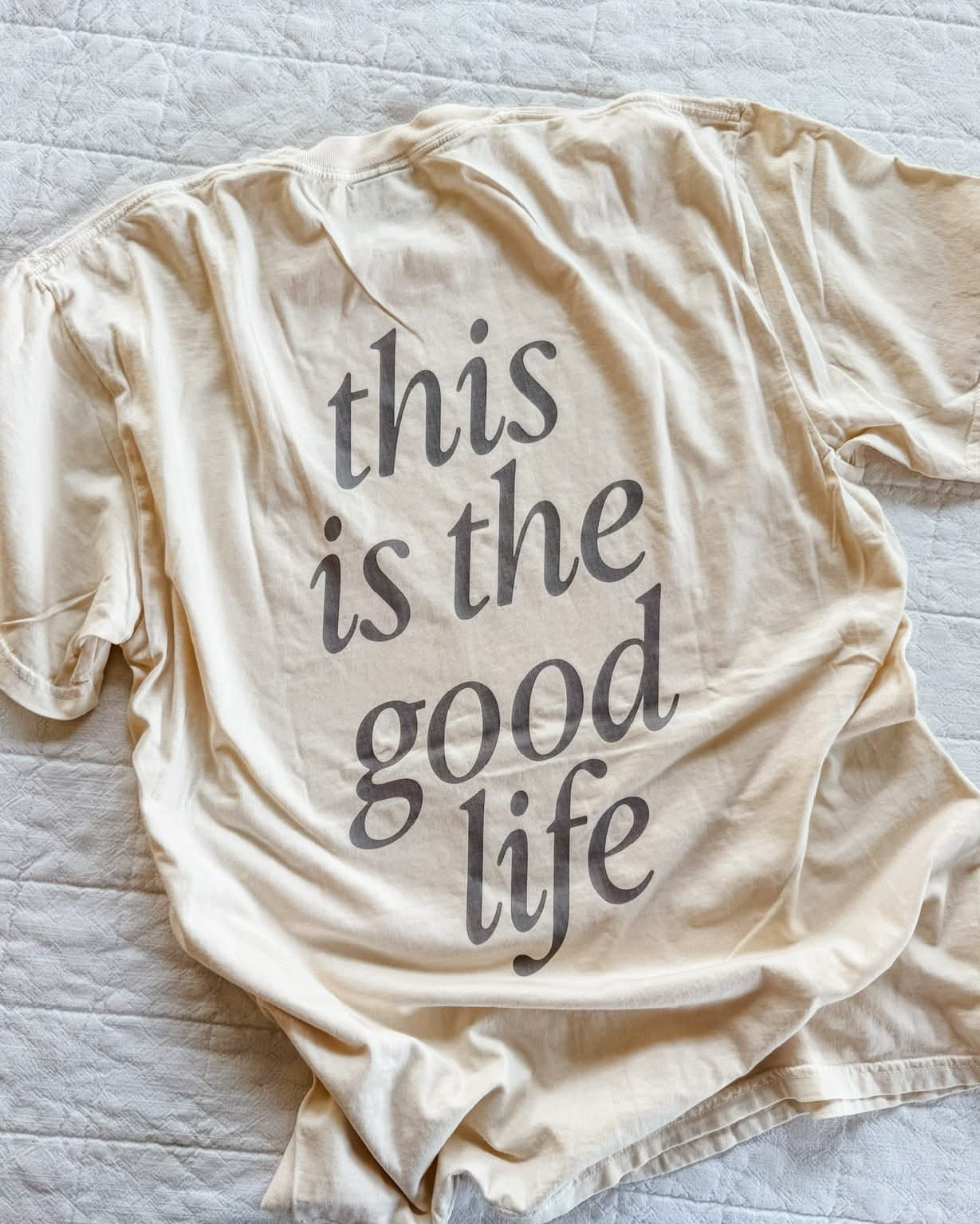 Adult tee in ivory with 'this is the good life' printed on the back, seen on flat lay - Little Mama Shirt Shop