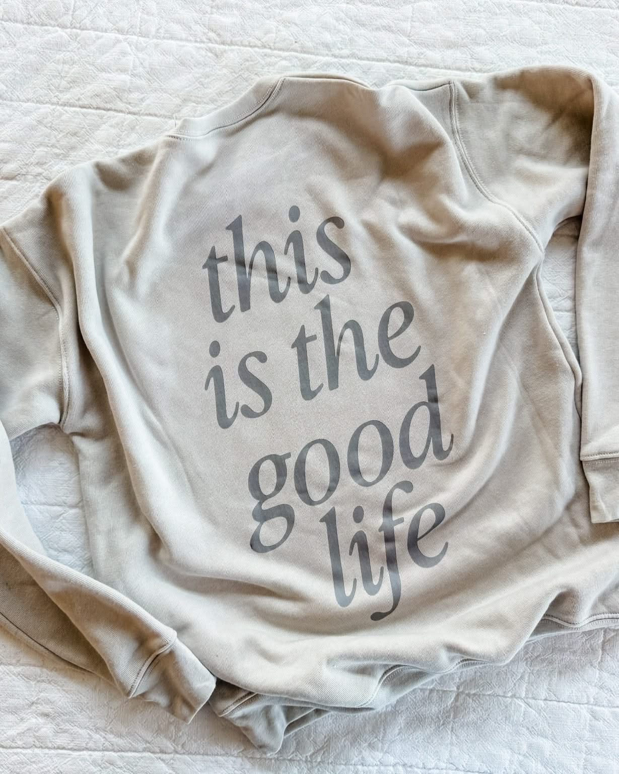 Adult fleece in cream with 'this is the good life' printed on the back, seen on flat lay - Little Mama Shirt Shop
