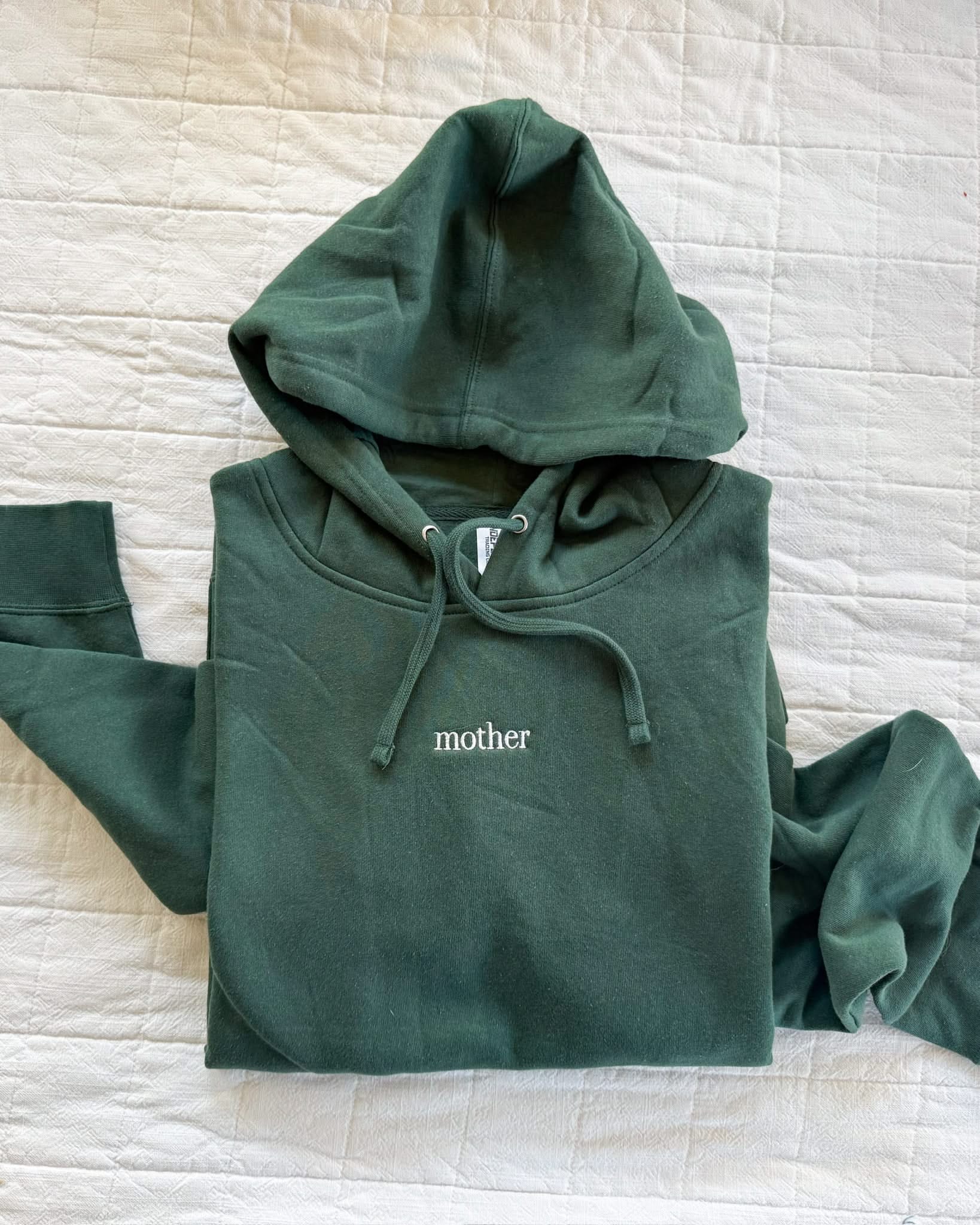 Adult alpine hoodie with mother embroidered on the chest, seen on flat lay - Little Mama Shirt Shop