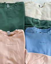 Adult crewneck in alpine, cream, blush, and light blue with mama, mom, or mother embroidered on the chest, seen on flat lay - Little Mama Shirt Shop