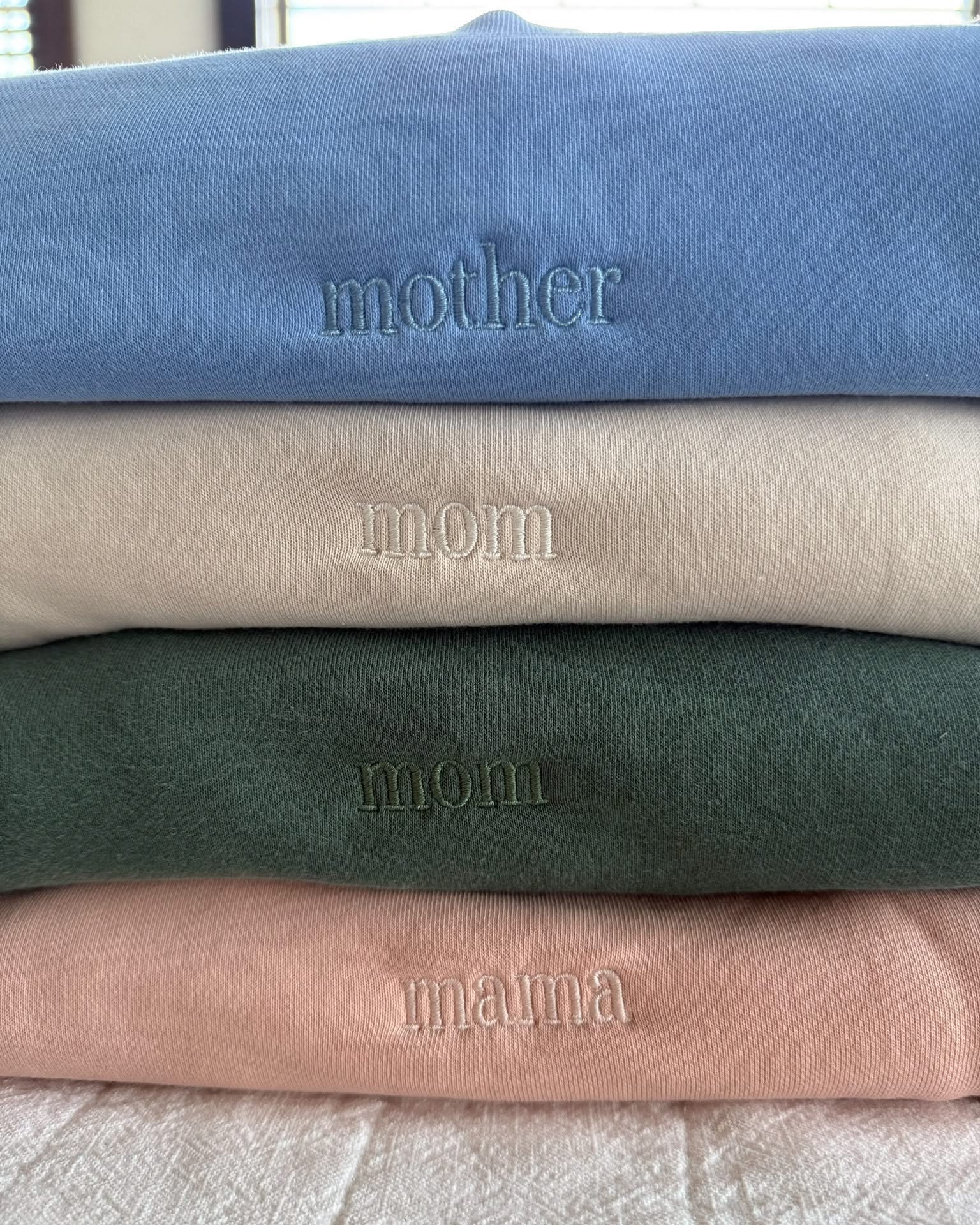 Adult crewneck in alpine, cream, blush, and light blue with mama, mom, or mother embroidered on the chest, seen on flat lay - Little Mama Shirt Shop