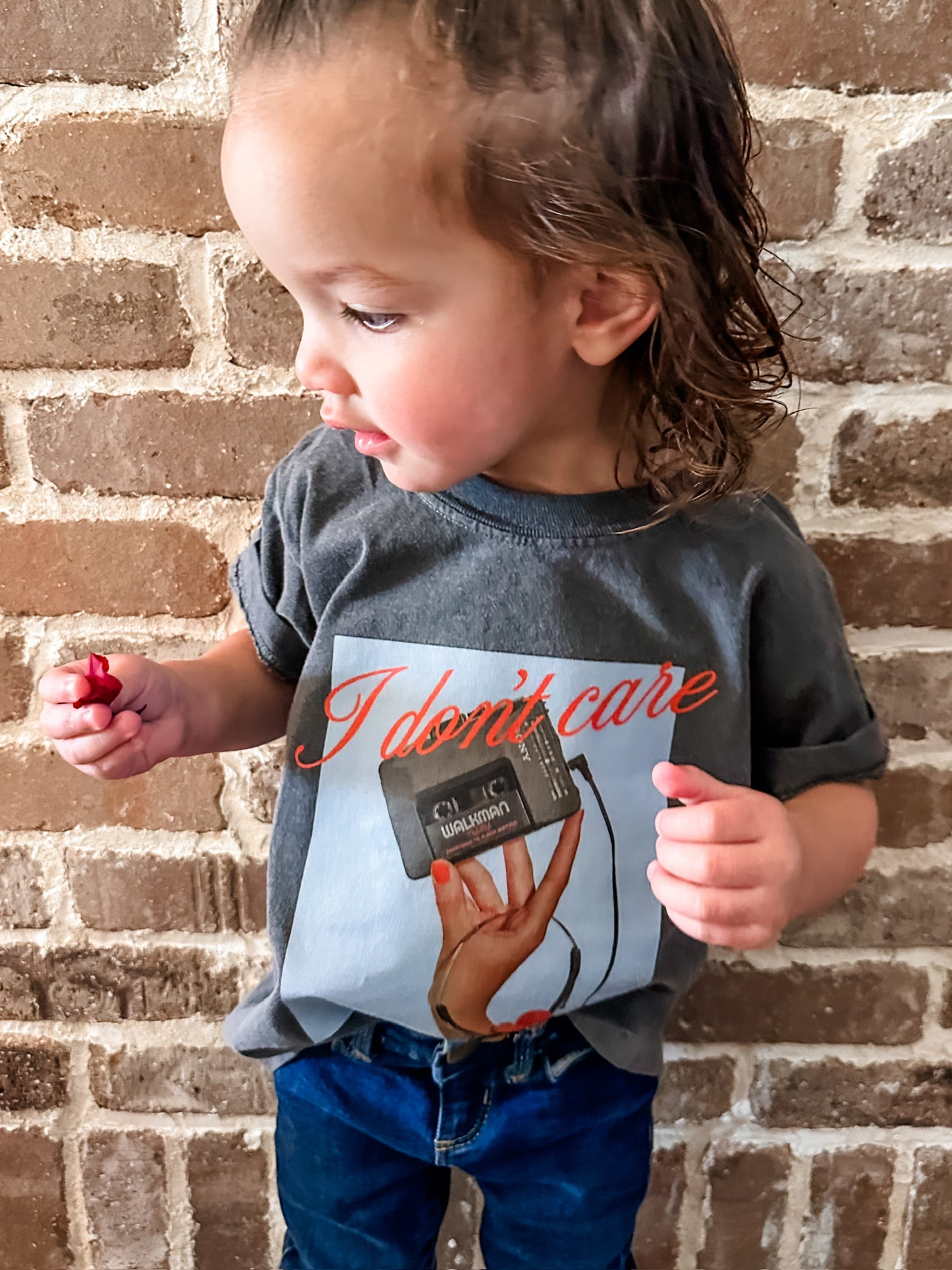 Child tee with "I Don't Care" retro cassette on front and "JK I Actually Do" text on sleeve, shown on model  – Little Mama Shirt Shop