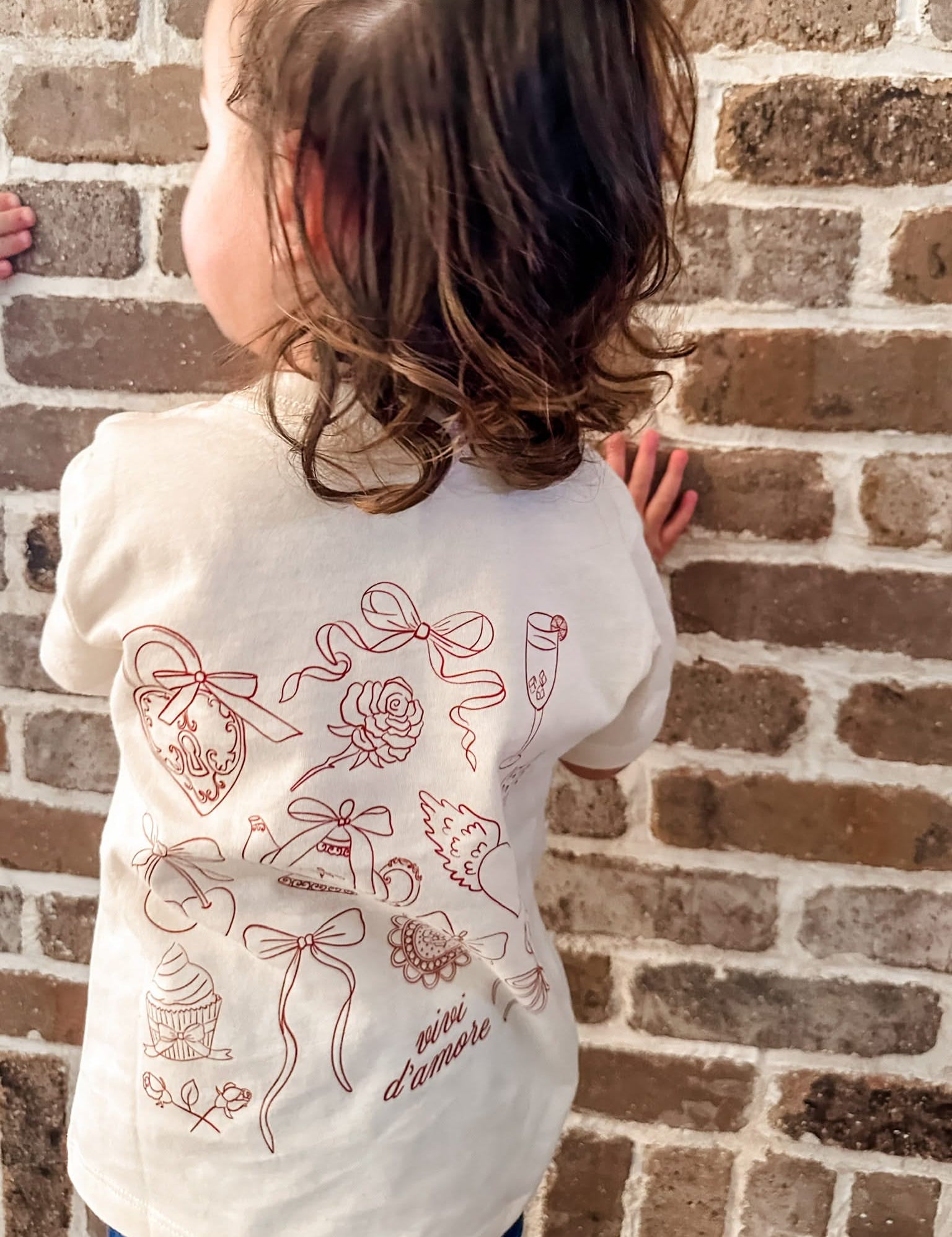 Child tee in natural with Valentines collage design on back, shown on model – Little Mama Shirt Shop