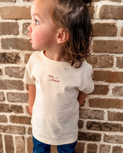 Child tee in natural with "More Amore" print on front, shown on model– Little Mama Shirt Shop