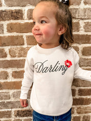 Child white sweater with "Darling" script and lipstick kiss design, shown on model  – Little Mama Shirt Shop
