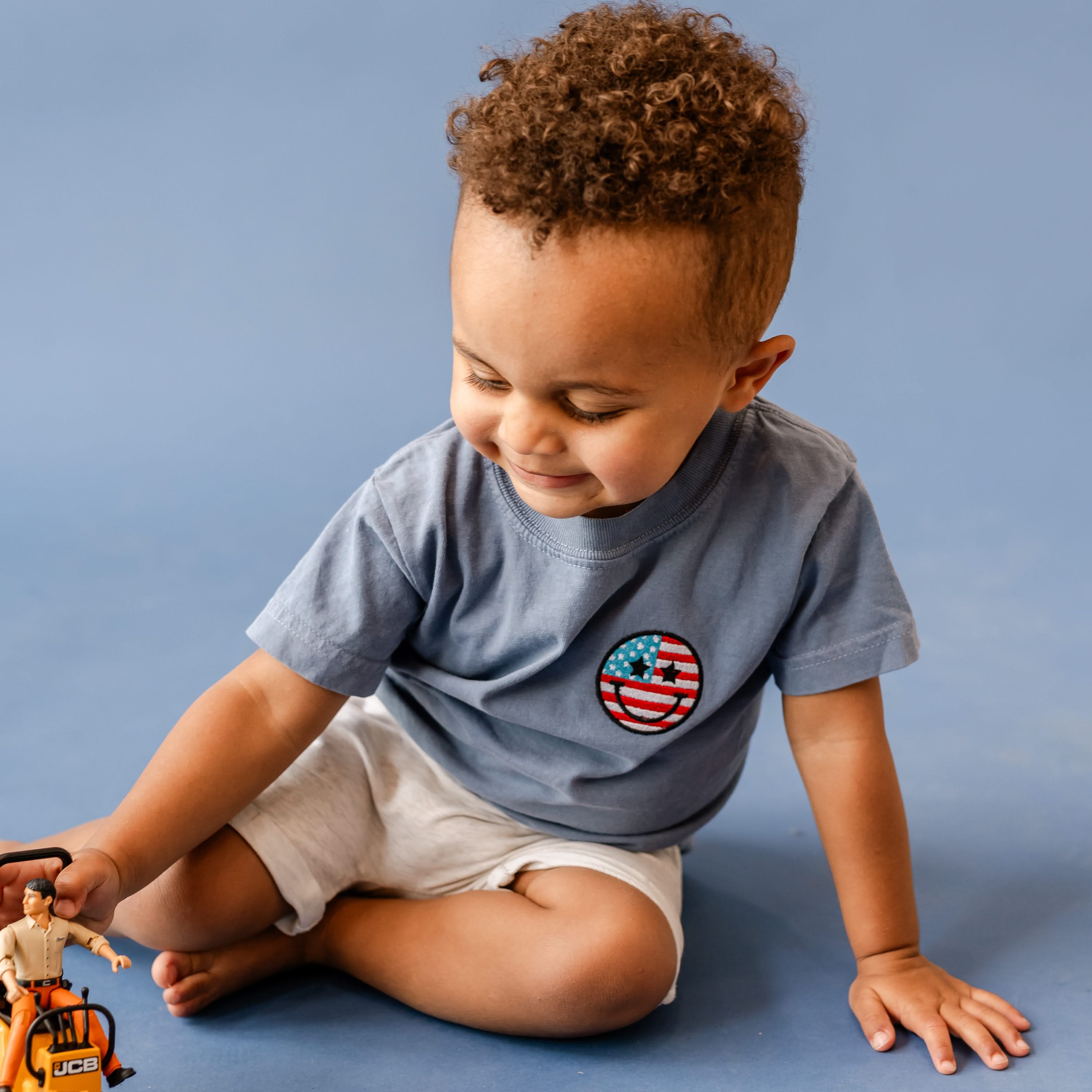 Embroidered YOUTH Comfort Colors Tee - Star Eye Smiley Flag (pocket) Little Mama Shirt Shop