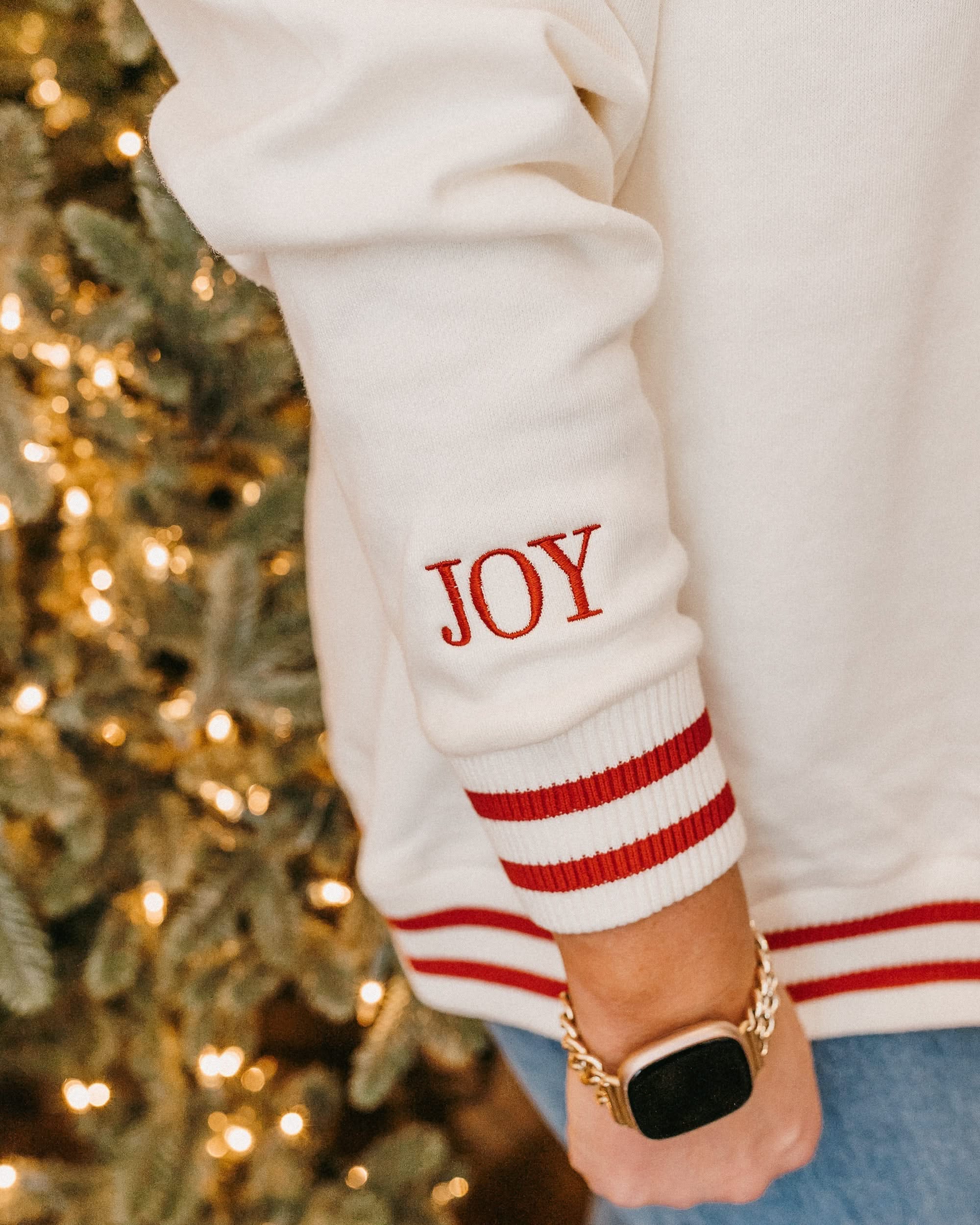 V neck sweater in white with red stripes on cuffs with embroidered 'JOY' embroidered on cuff, shown on model – Little Mama Shirt Shop