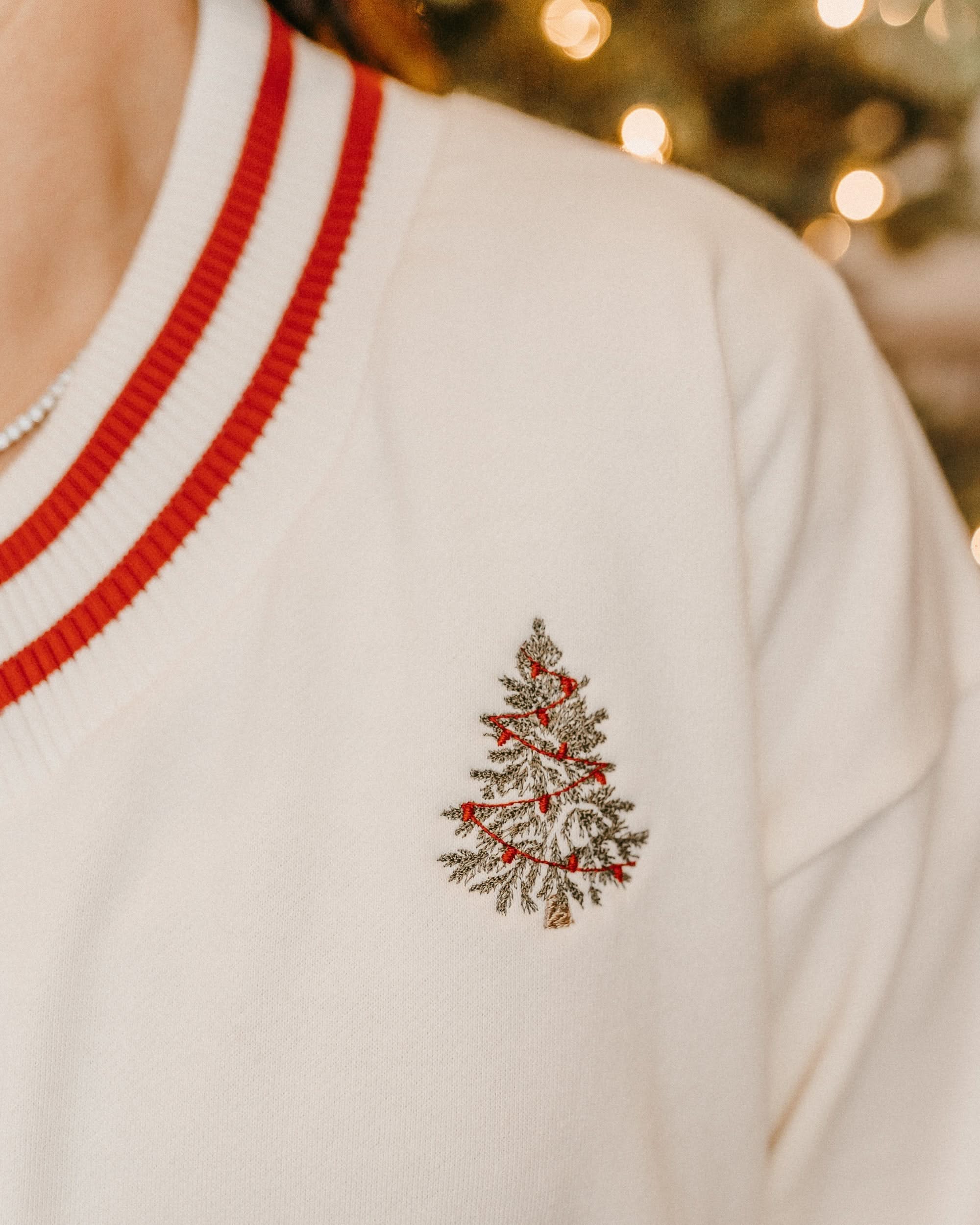 V neck sweater in white with red stripes on cuffs with embroidered Christmas tree on front, shown on model – Little Mama Shirt Shop