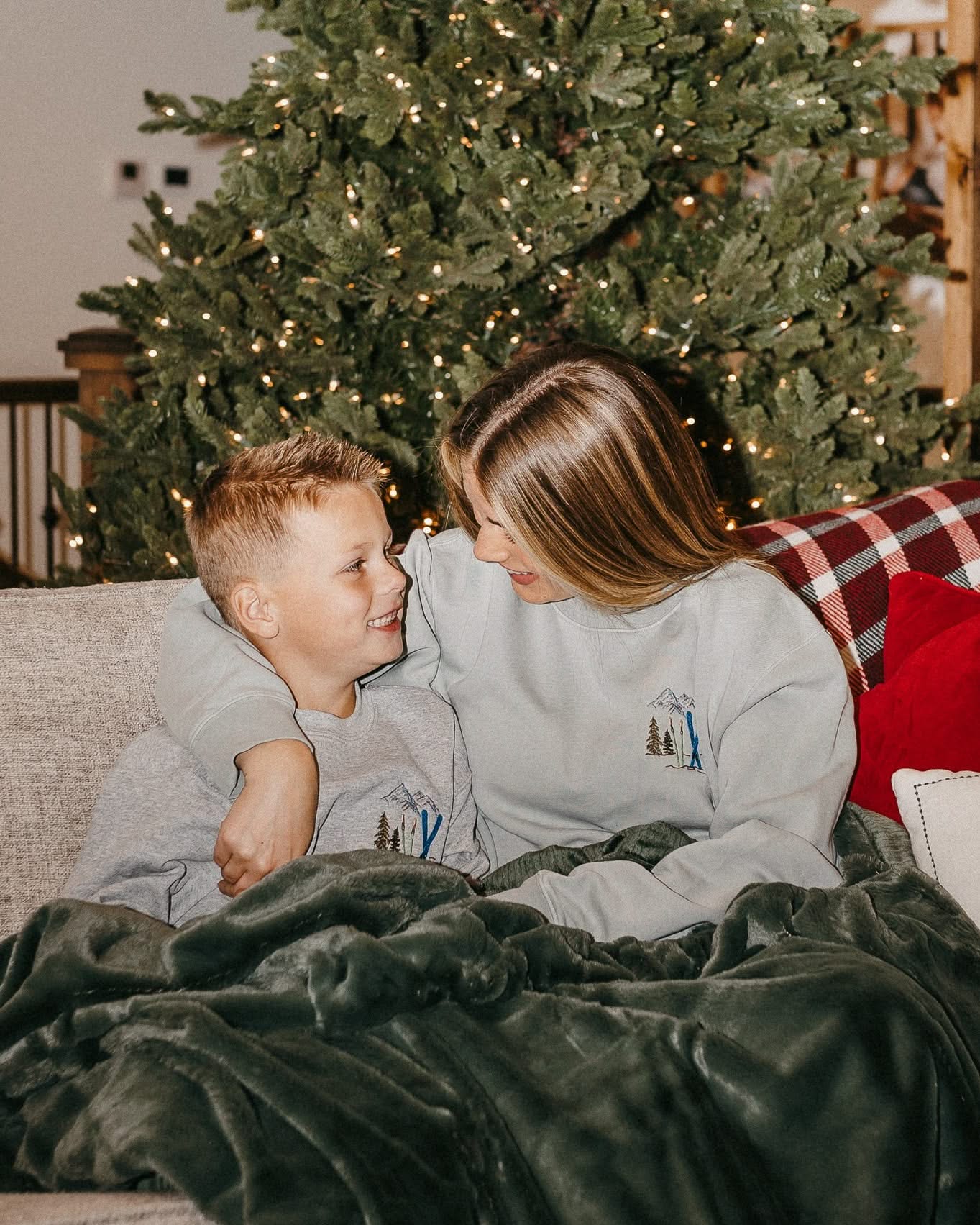 Child sweater in gray and adult sweater in sage with embroidered ski pattern, shown on model – Little Mama Shirt Shop