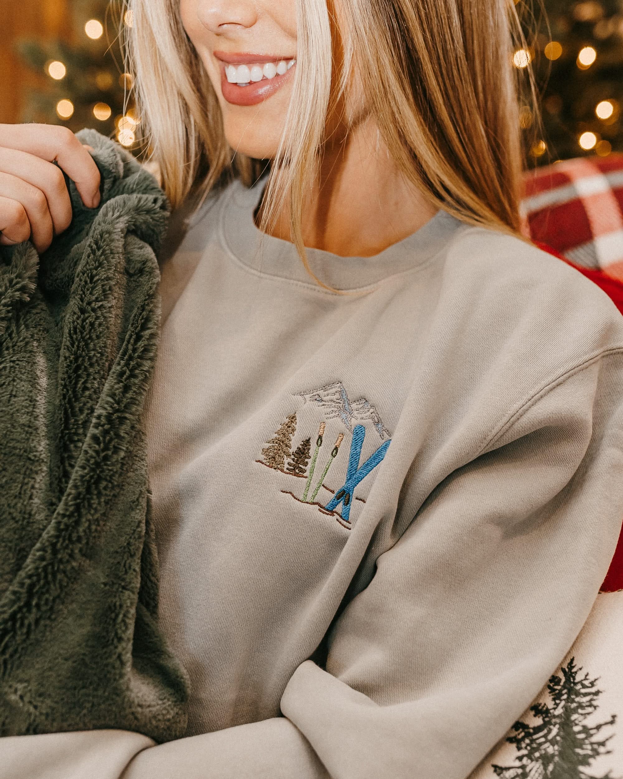 Adult sweater in sage with embroidered ski pattern, shown on model – Little Mama Shirt Shop