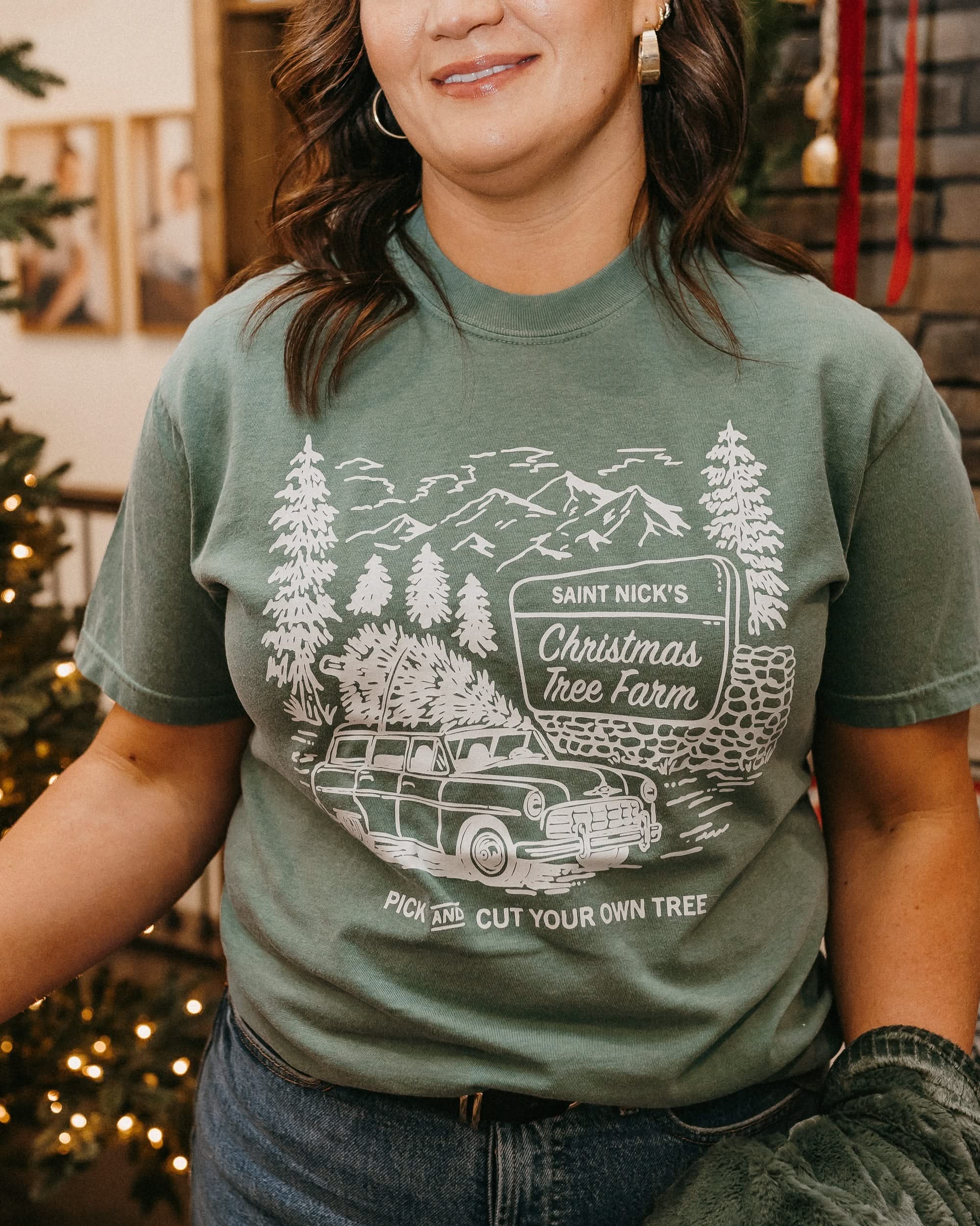 Comfort Colors Tee in light green with St. Nick's Christmas Tree Farm graphic on the front, shown on model – Little Mama Shirt Shop