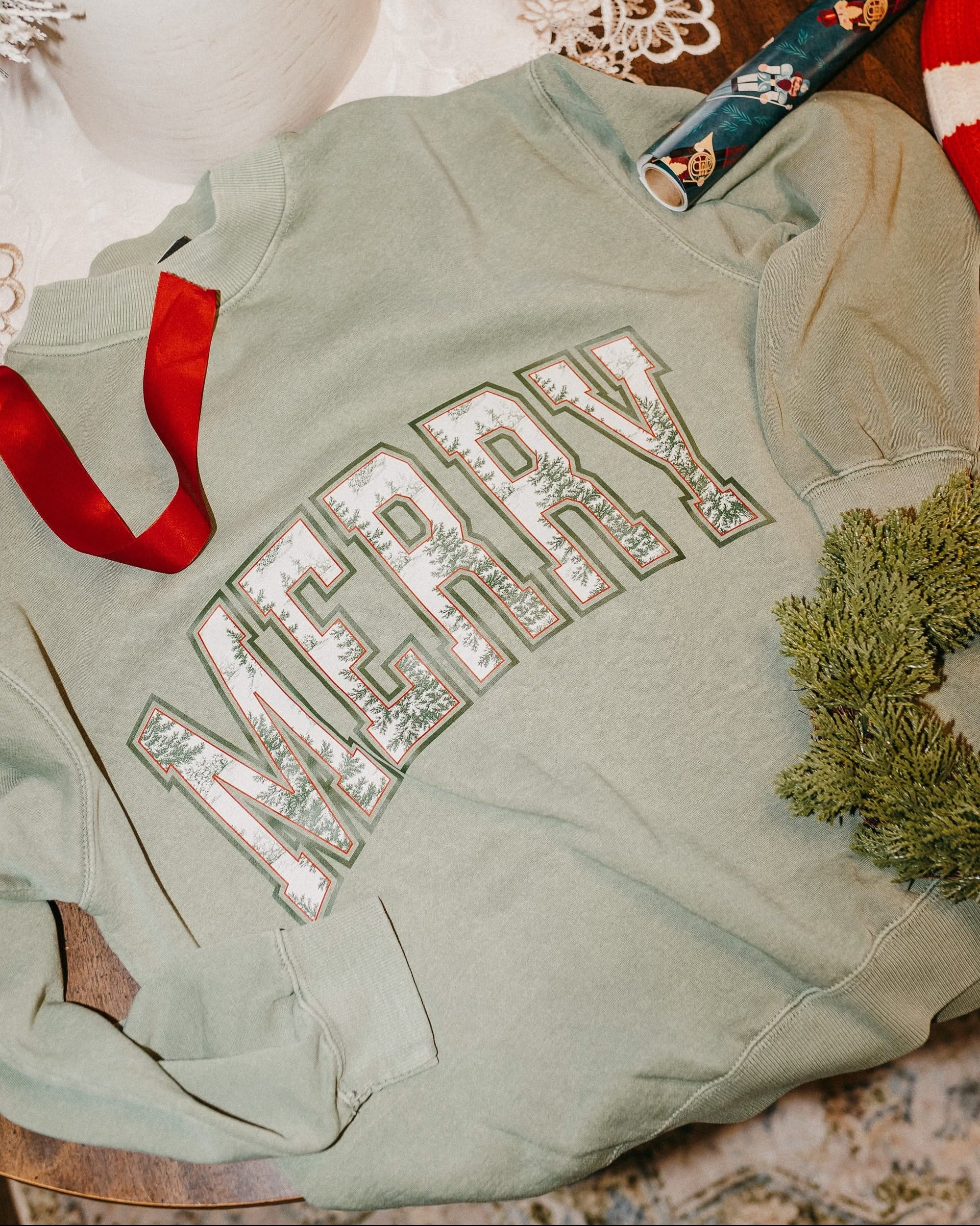 Adult mock neck sweater in green with 'Merry' graphic, shown on flat lay – Little Mama Shirt Shop