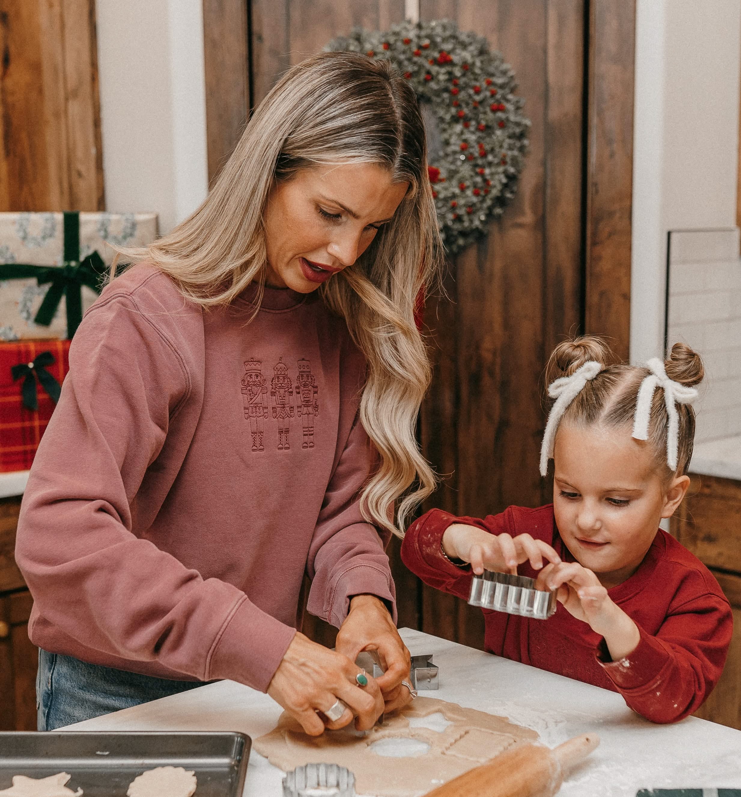 Adult sweater in dusty pink with 3 embroidered nutcrackers on chest, shown on model – Little Mama Shirt Shop