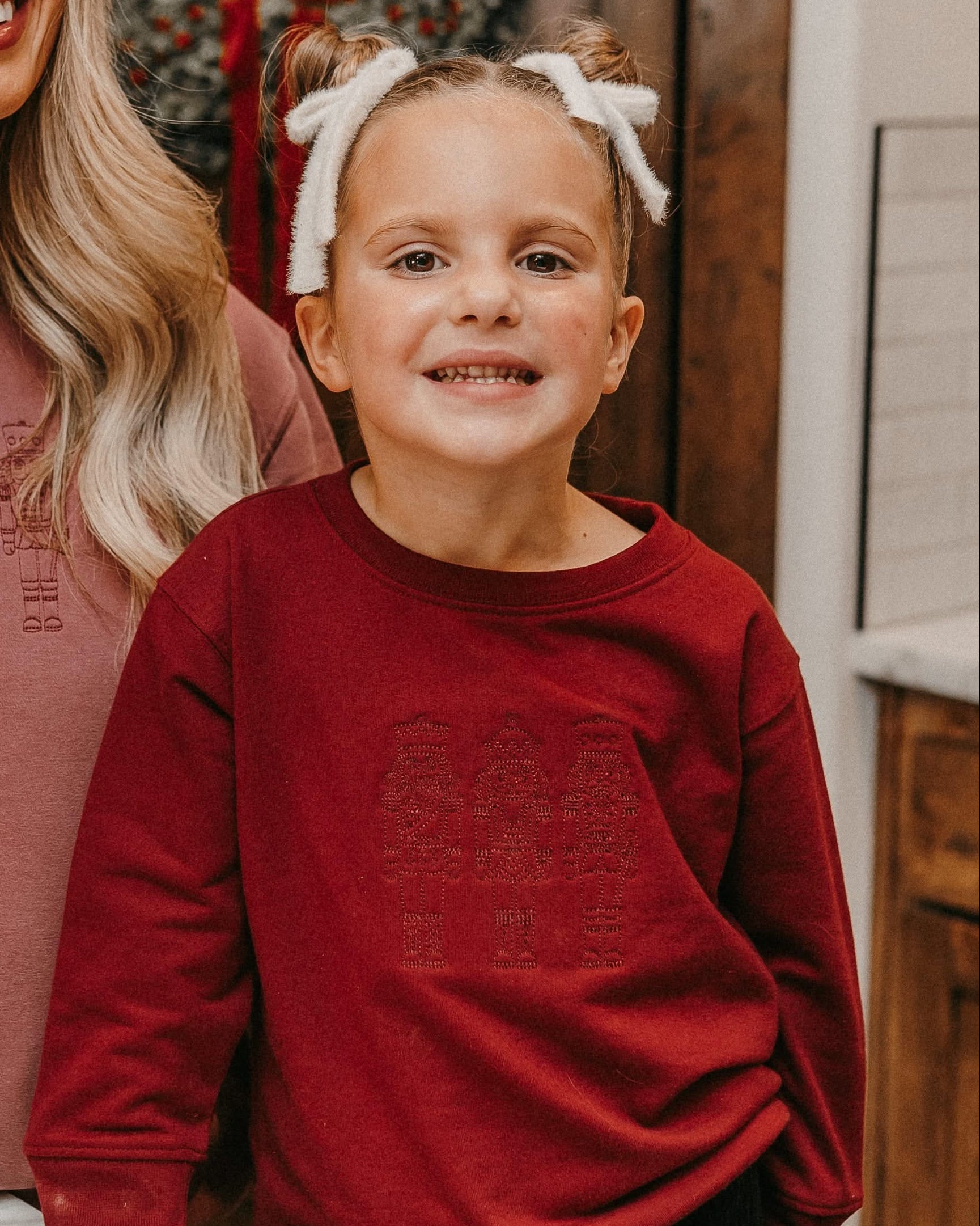 Child sweater in red with 3 embroidered nutcrackers on chest, shown on model – Little Mama Shirt Shop